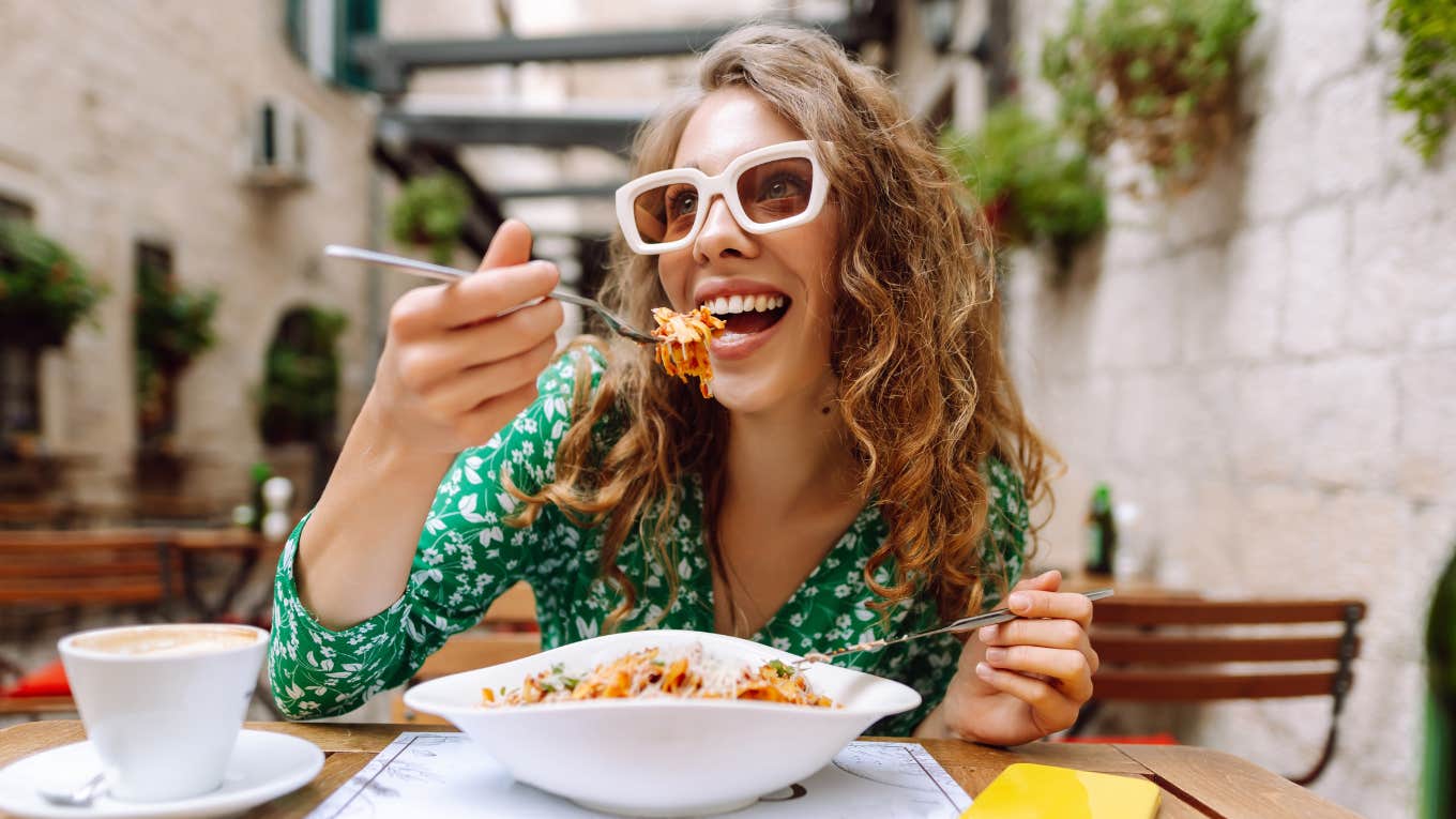 What Your Favorite Flavor Says About Your Personality, According To Psychology Woman eating her favorite flavor food revealing her personality