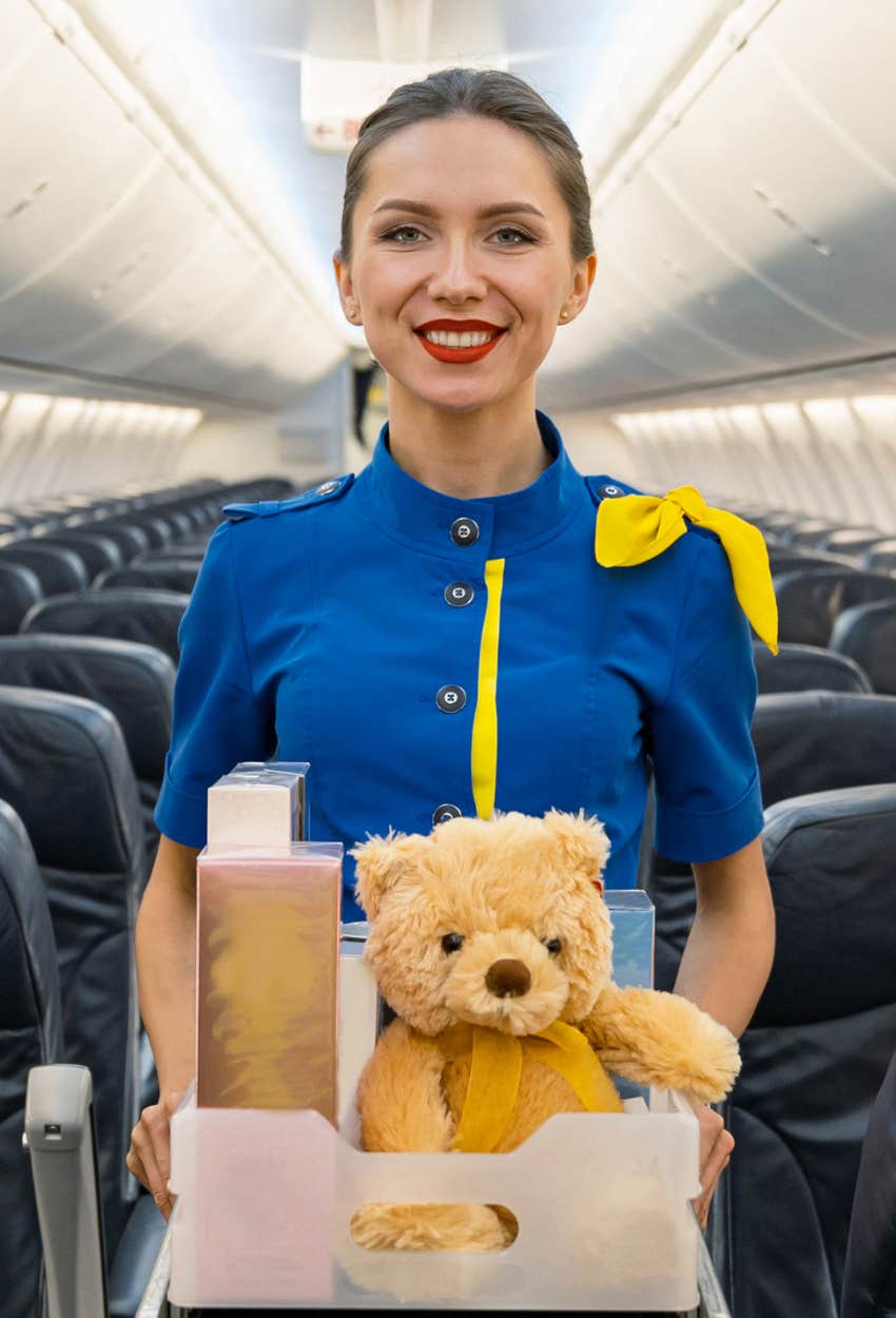 Flight attendant pushing drink cart down the aisle