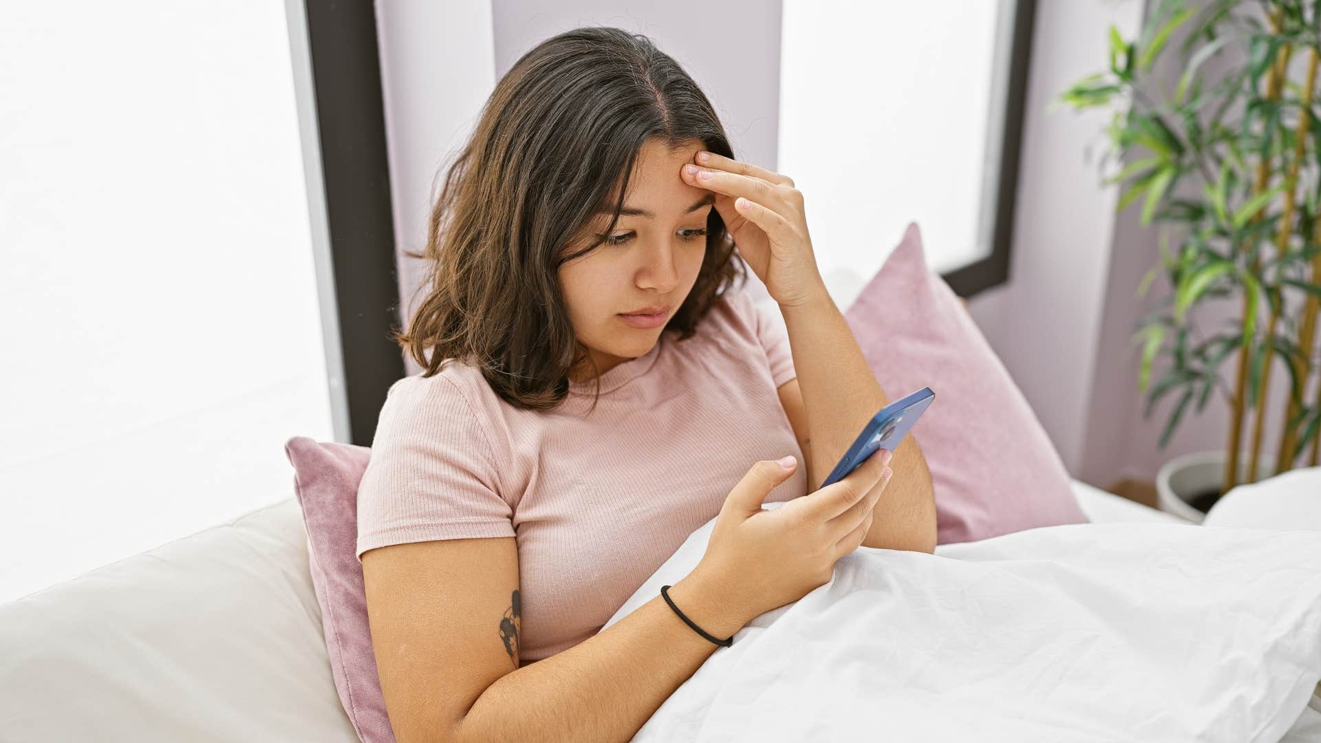 a young woman checks her phone despite saying she would not before taking a nap