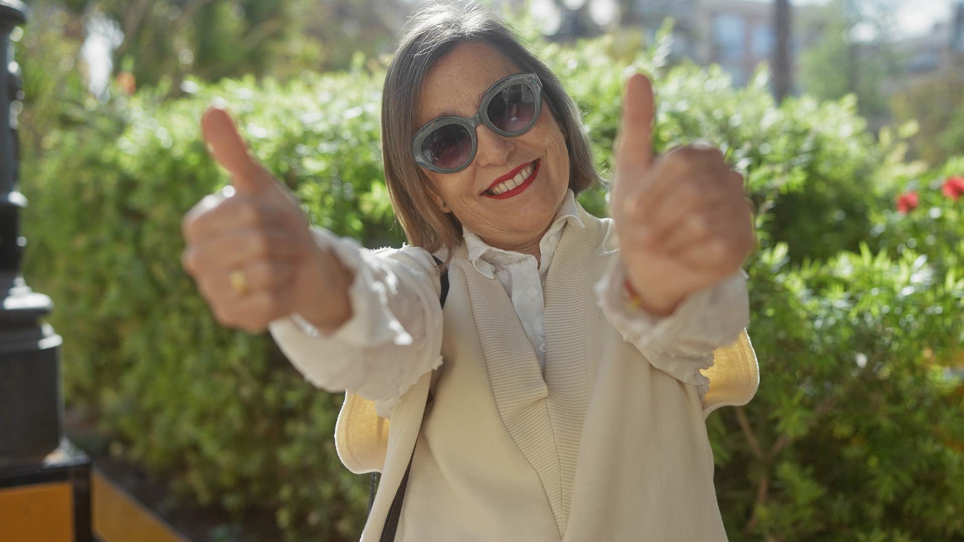 older woman reclaiming her self-expressing giving a thumbs up