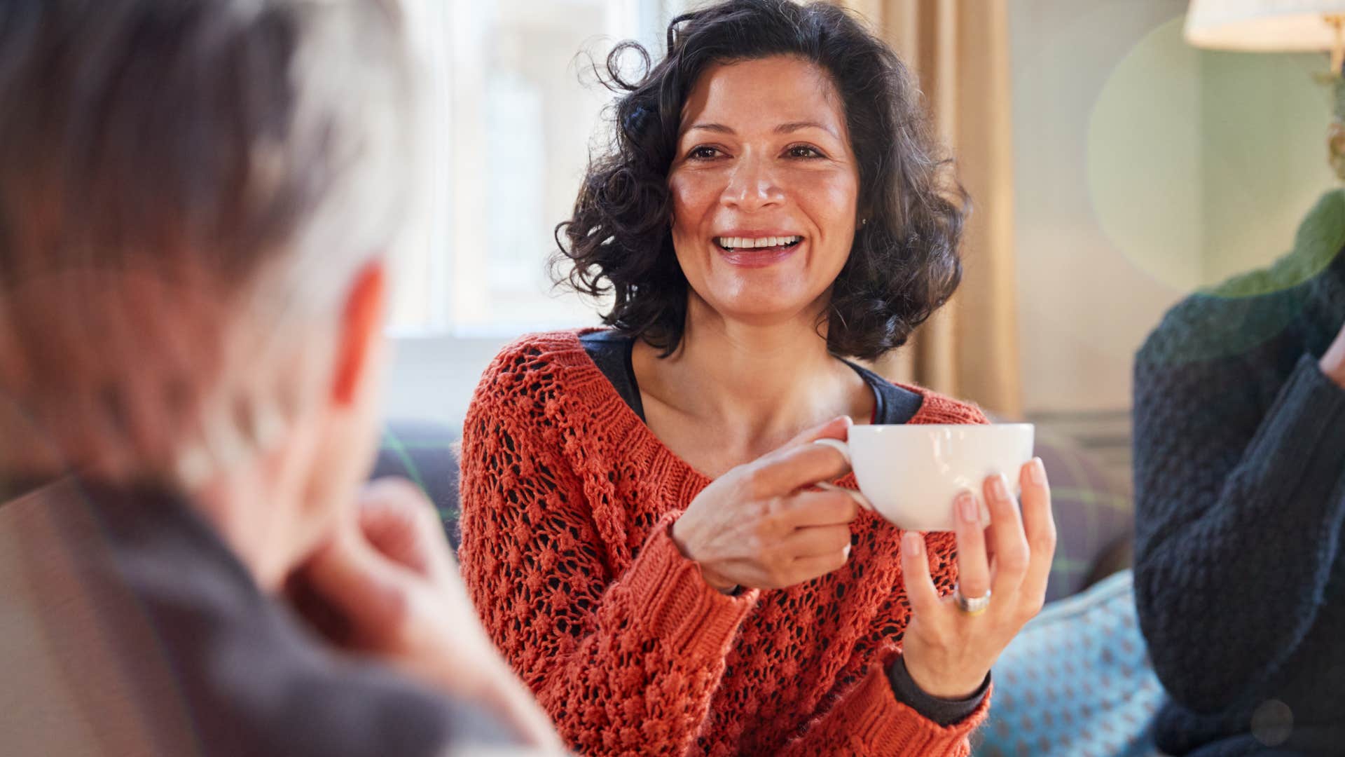 happy older woman who's respected for her knowledge and personality smiling with friends