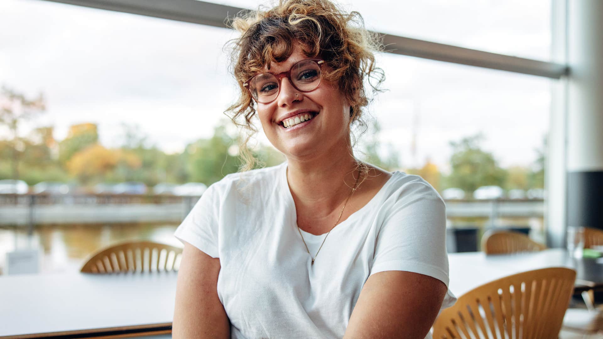 self-assured woman smiling at her desk