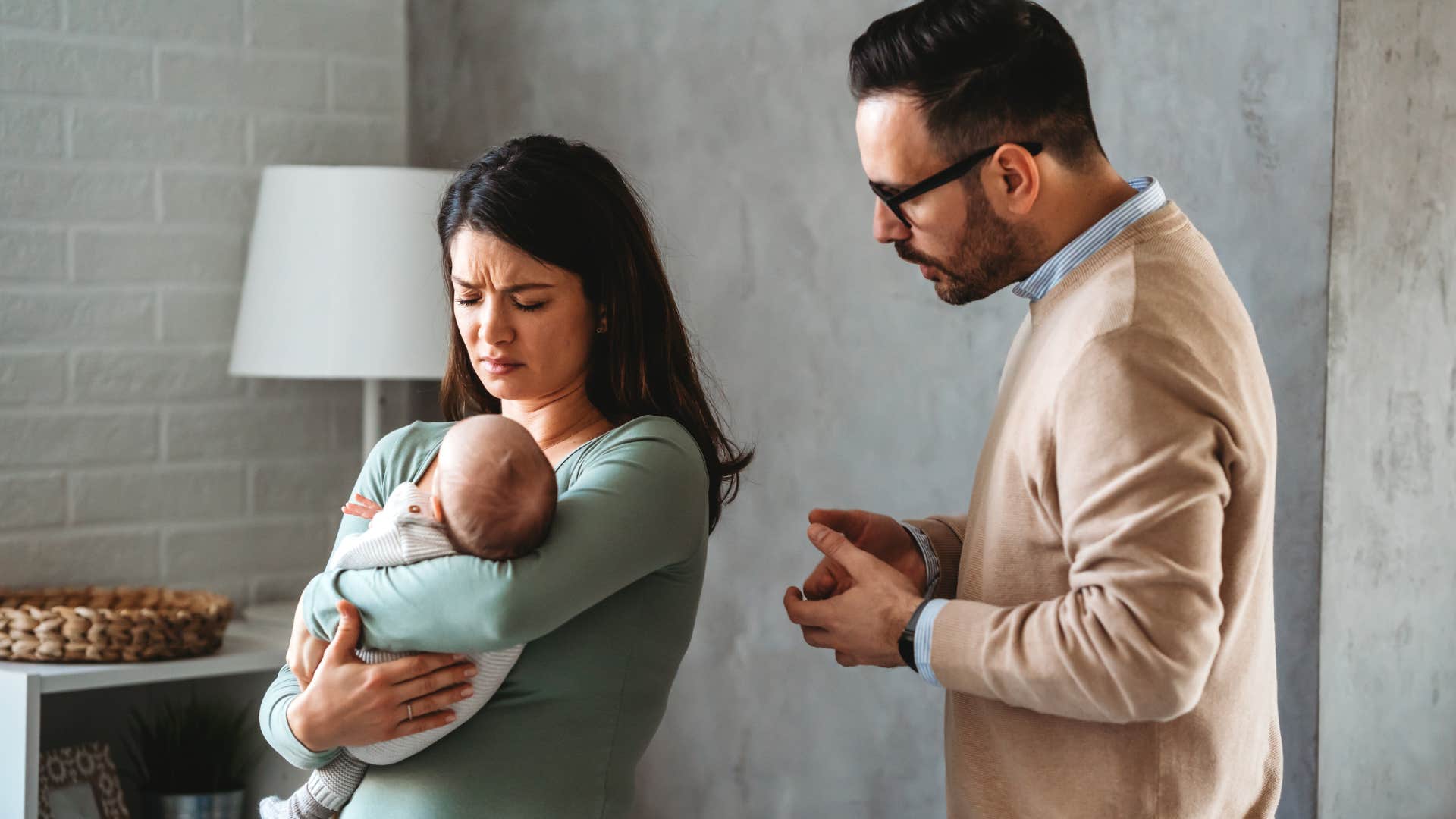 parents with different parenting styles talking and holding their baby