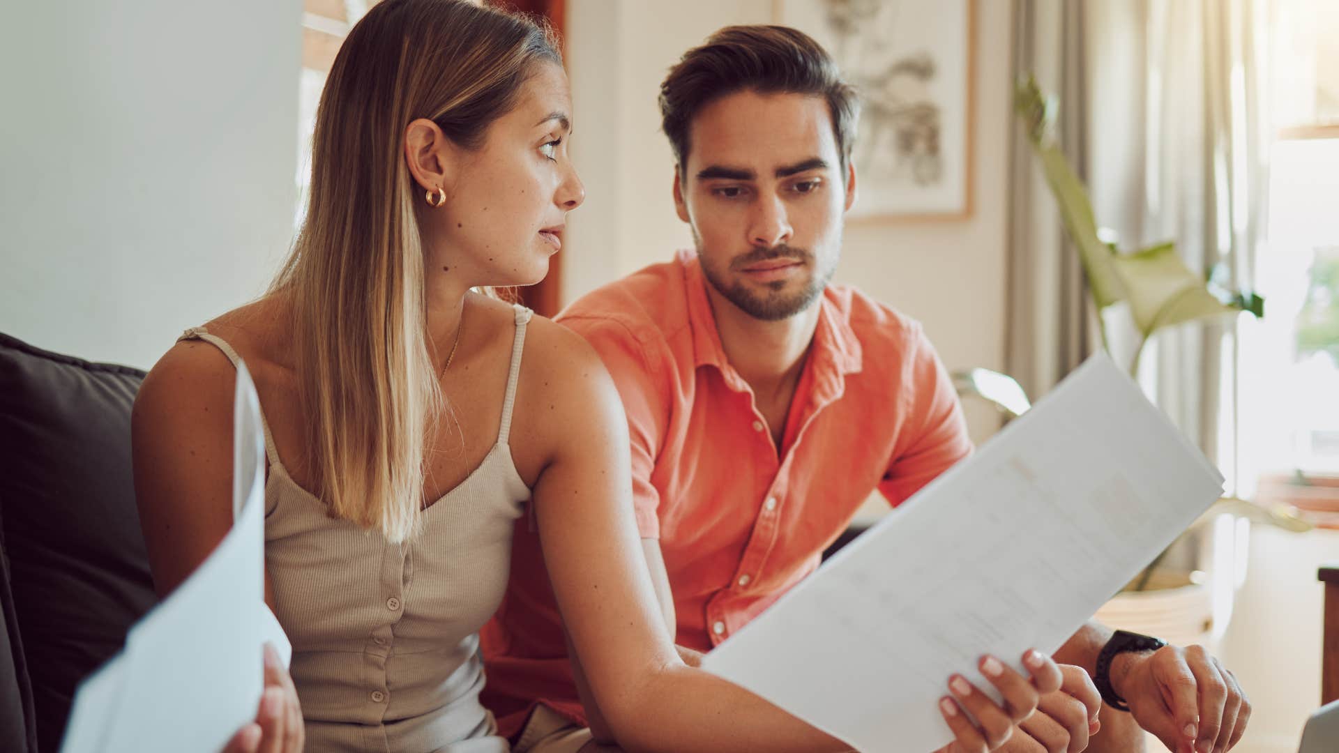 woman battling financial stress doing bills with her husband