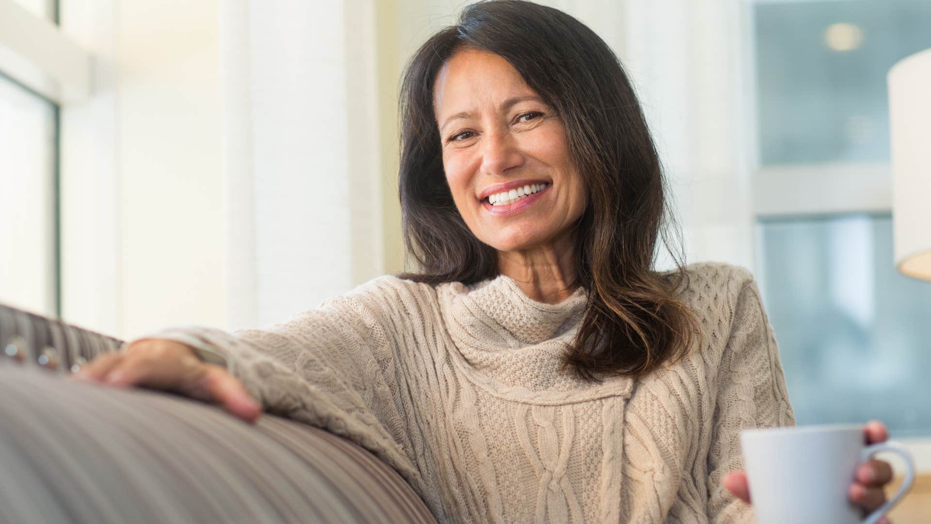 Woman who respects themselves smiling with a coffee cup.