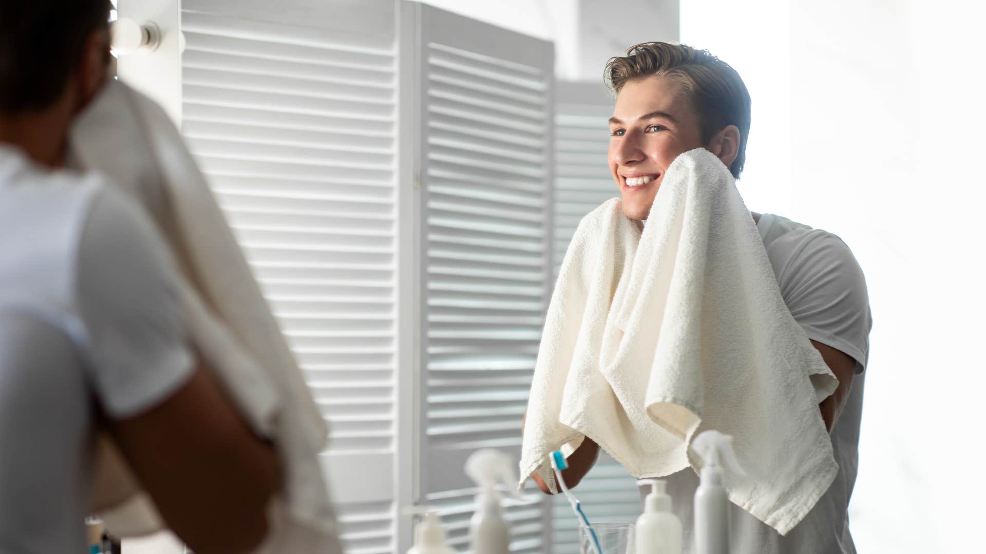 a man uses a separate towel to dry his face