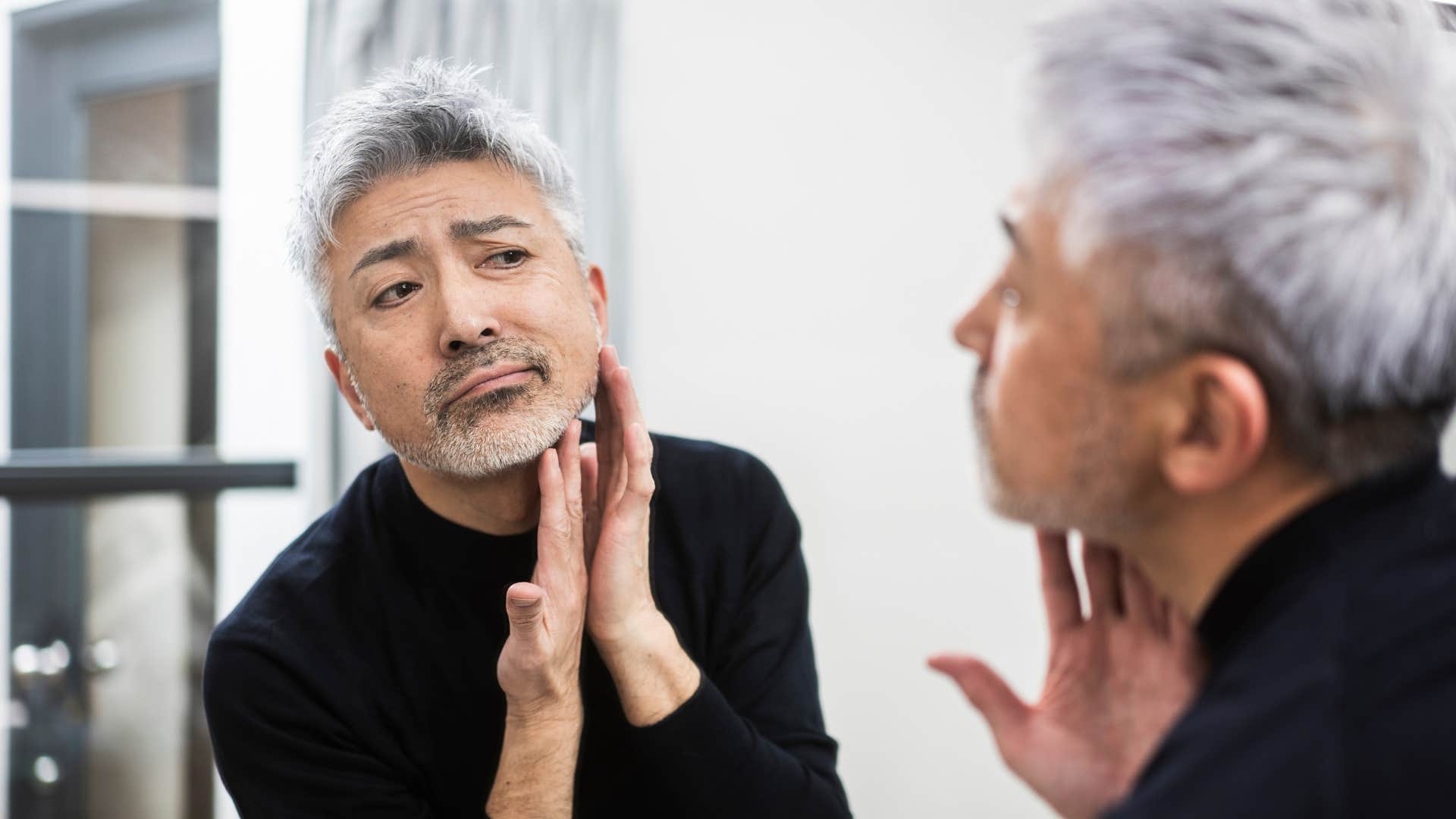 a man puts his hands on his face after washing them