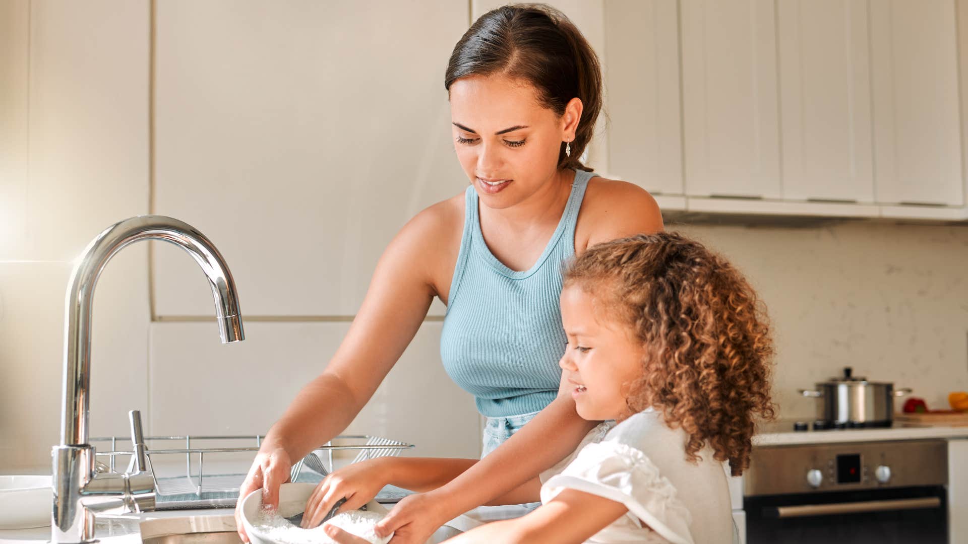 mother teaching her young daughter basic responsibilities