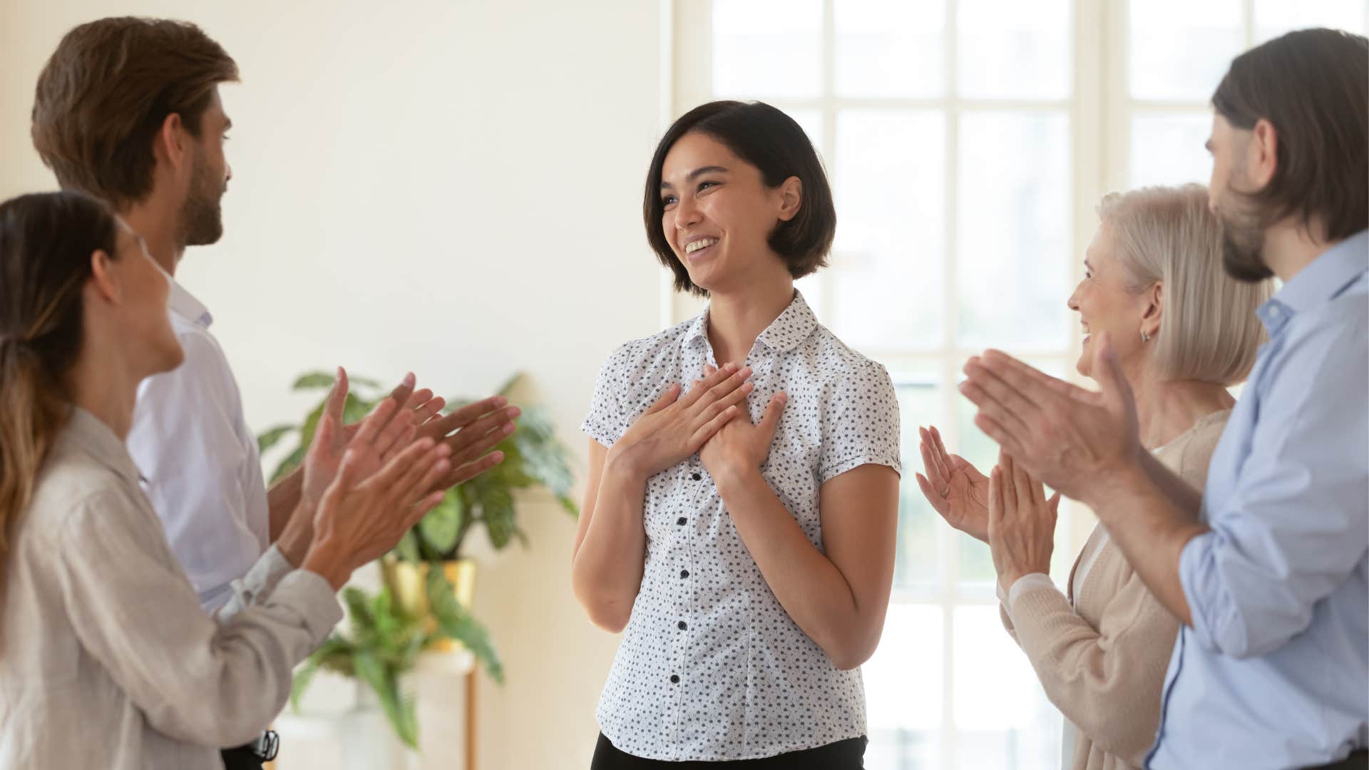 woman being praised by her co-workers as they celebrate her
