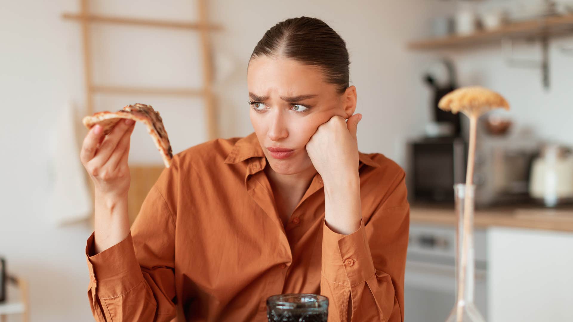 a woman feels guilt for eating the last slice of pizza