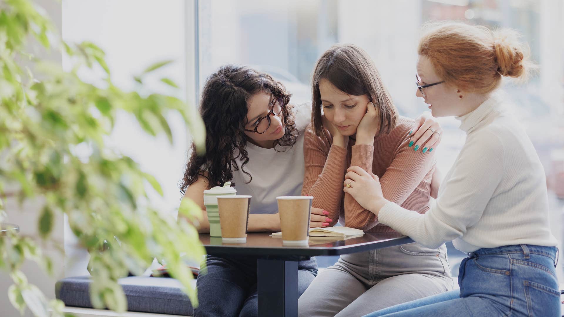 two successful young women comfort their friend who is struggling