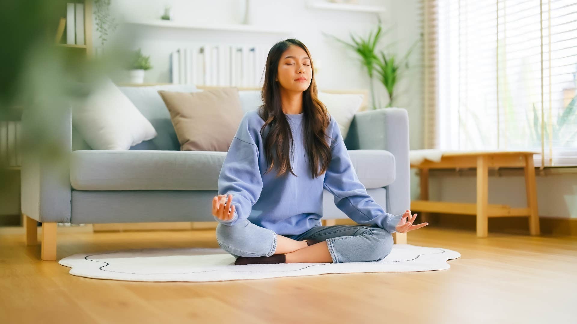 a woman takes time for herself to mediate in her home