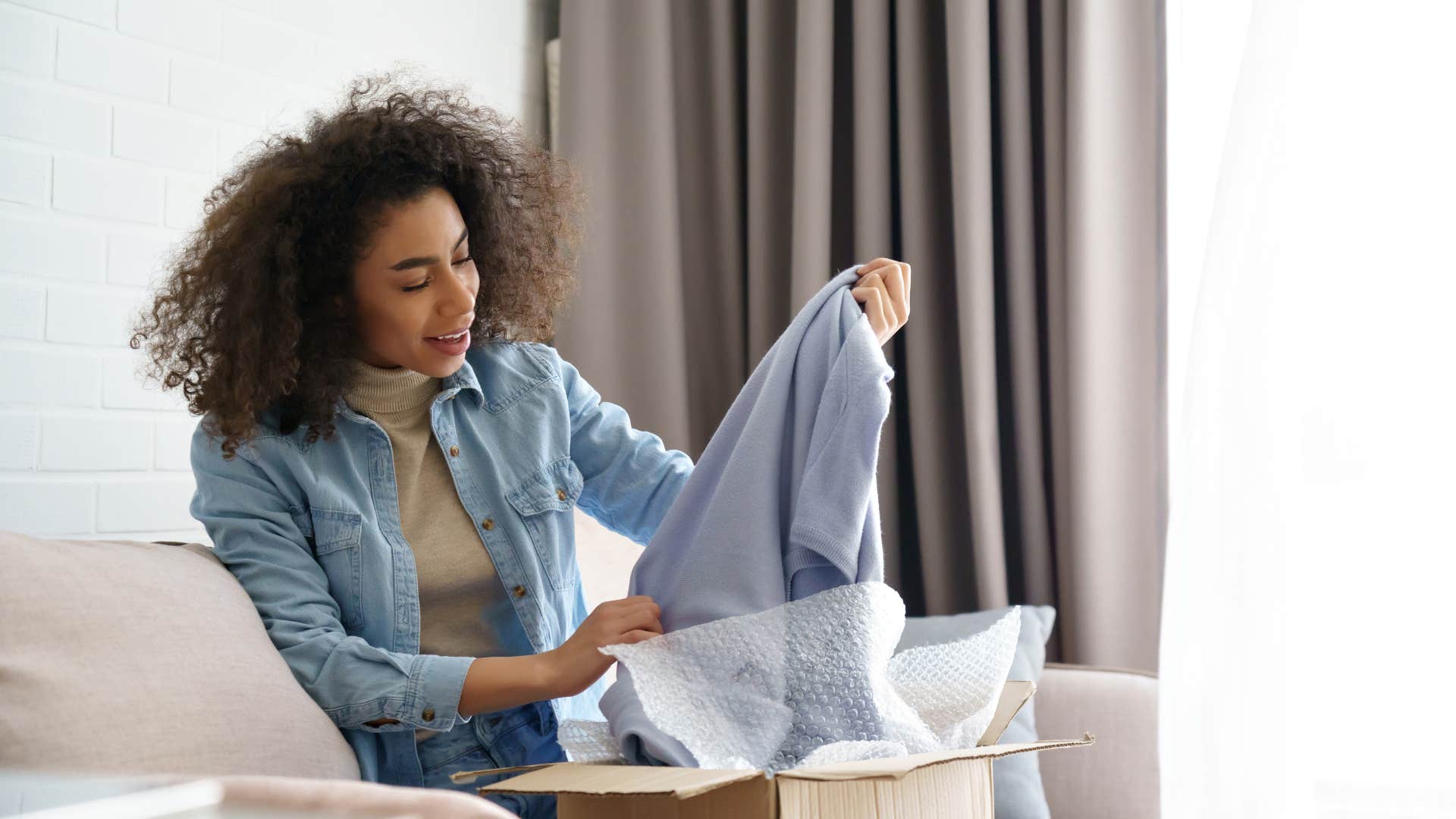 woman opening up package of clothes