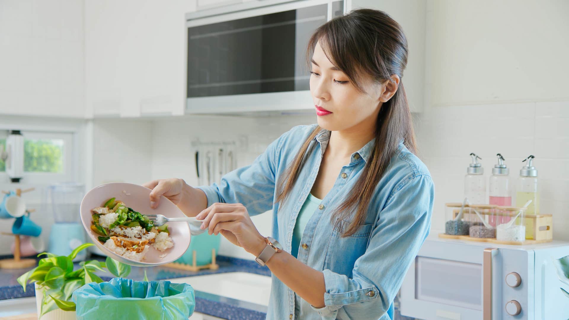 woman throwing away leftover food