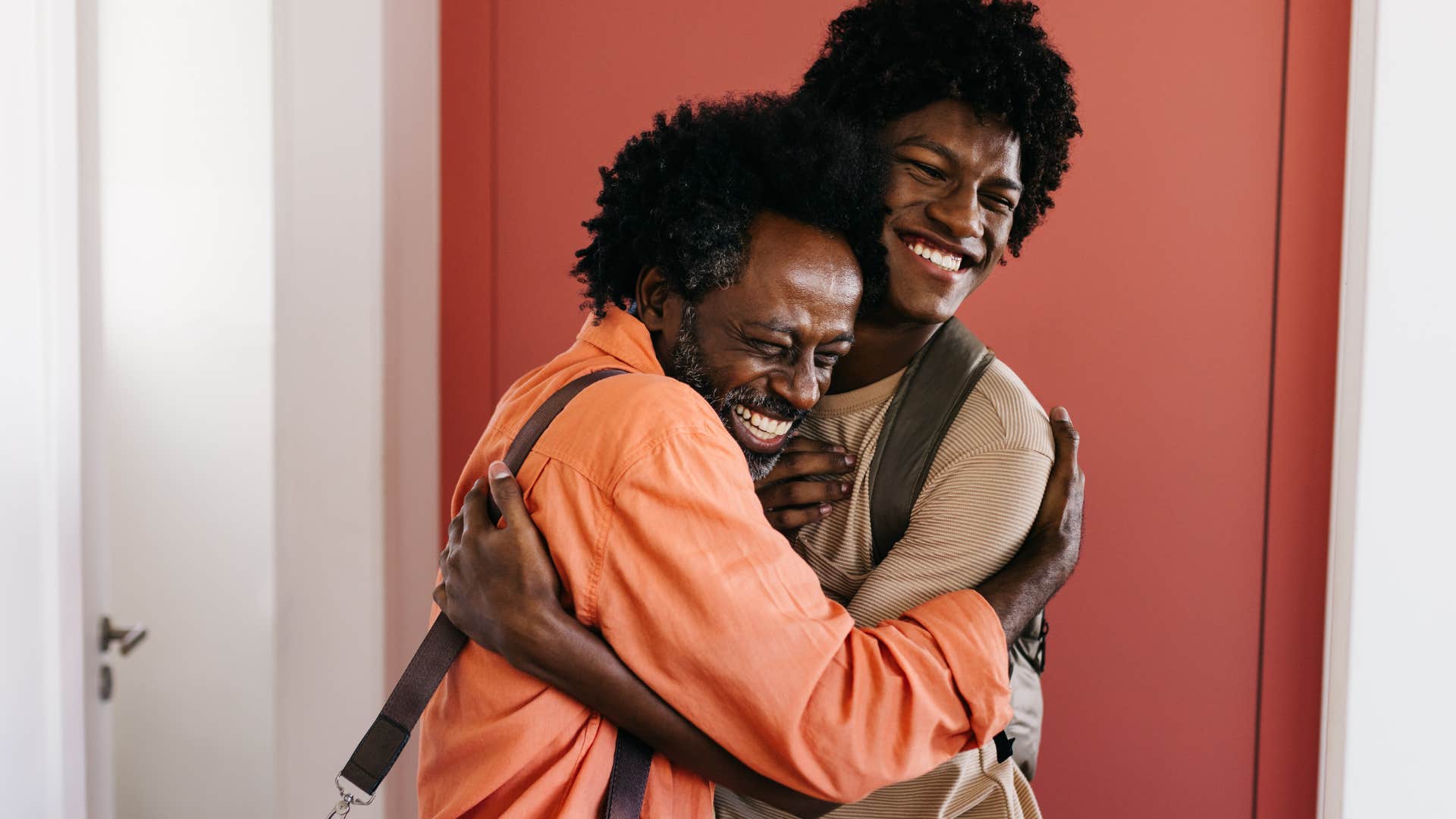 man smiling saying drive safe while hugging his dad