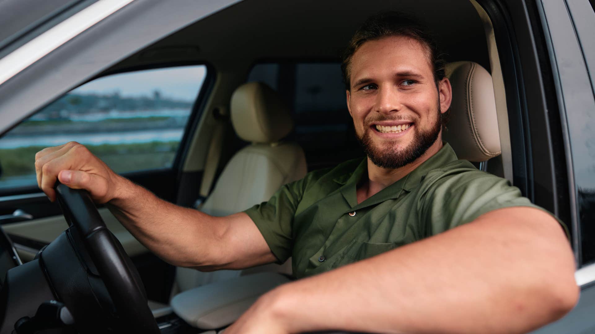 man smiling and letting people merge into traffic