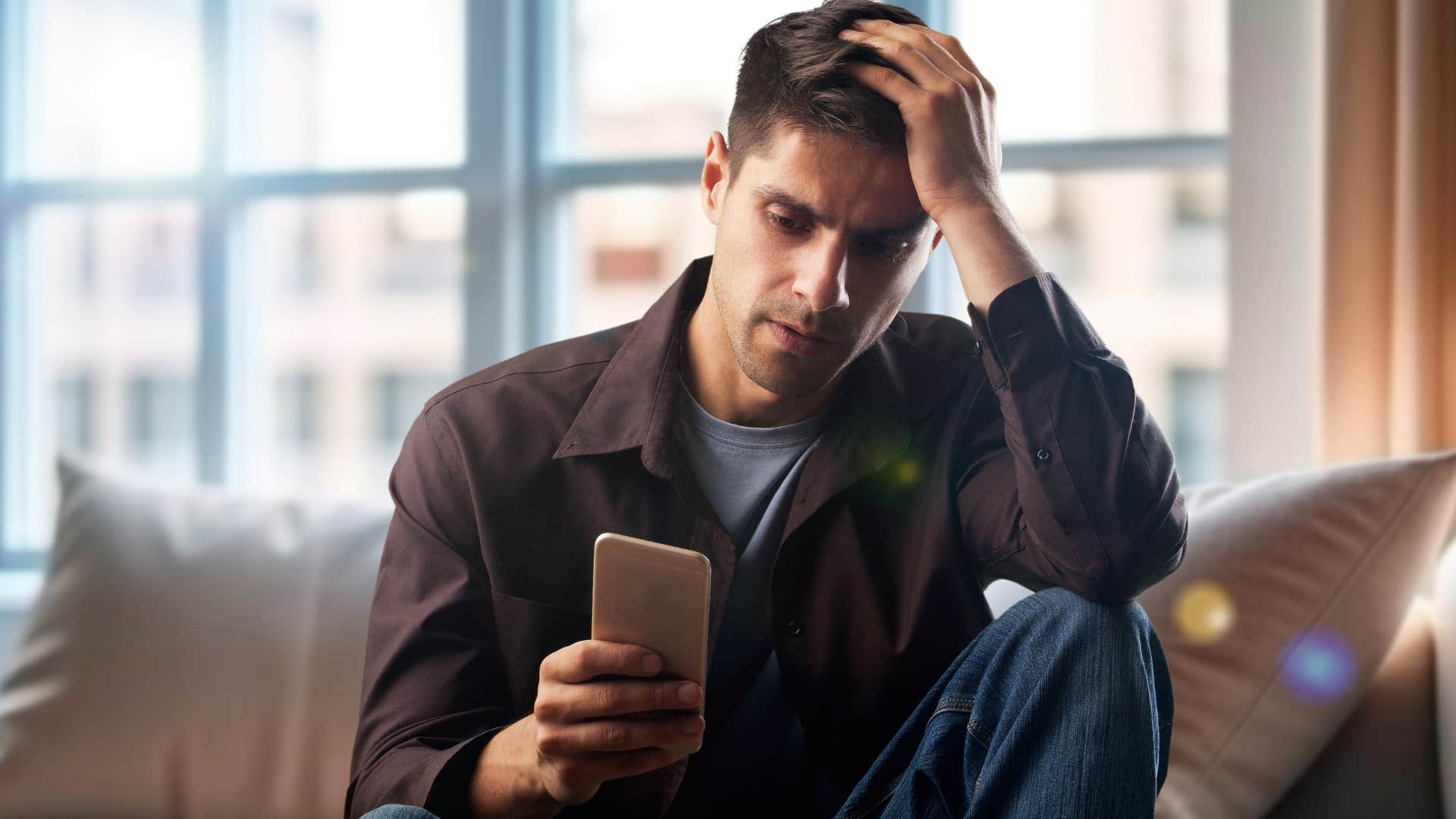 Man who doesn't feel like they can be themselves looking at their phone.