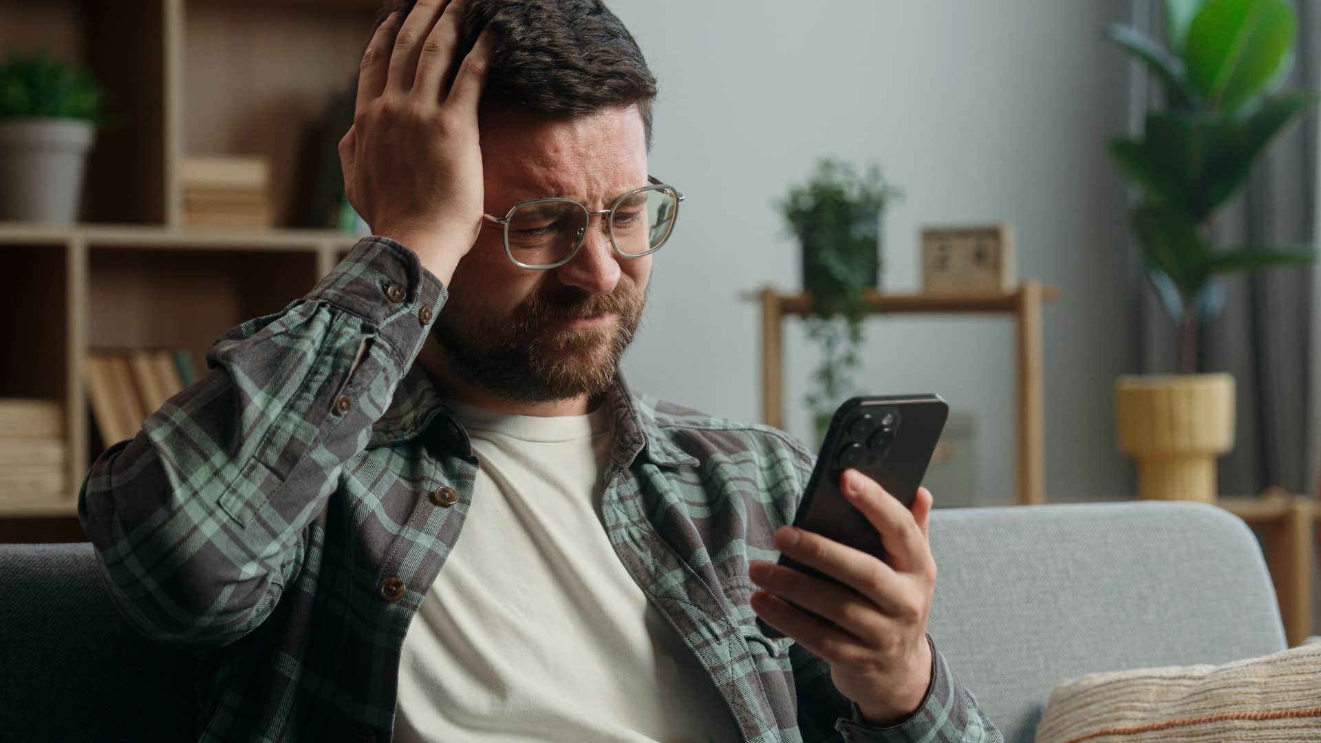 Man whose boundaries aren't respected looking at his phone.