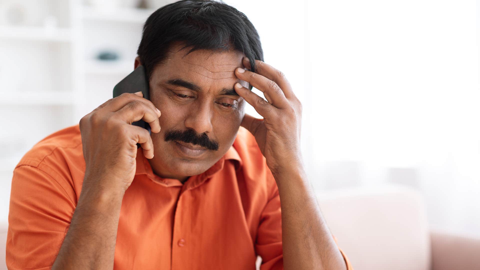 Man who feels like a child talking on the phone.
