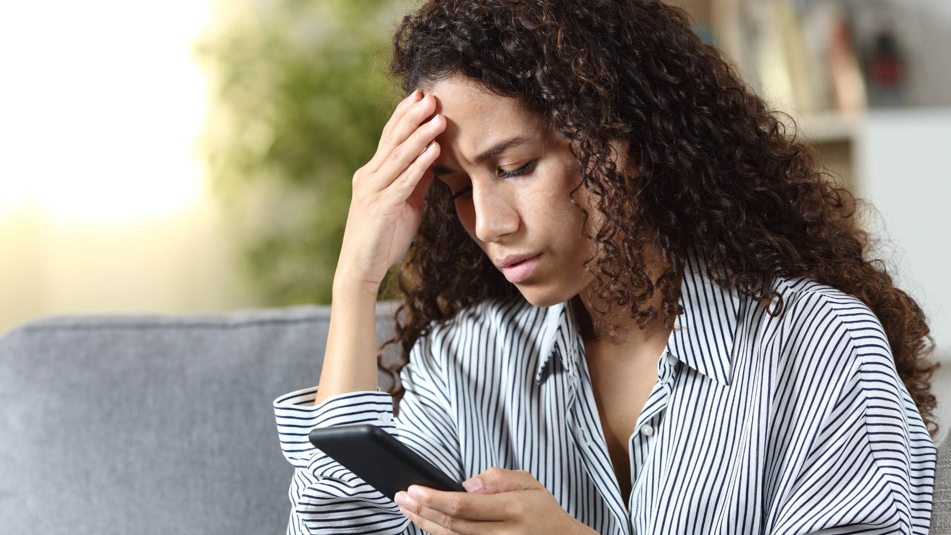 Woman with unresolved trauma looking at her phone.