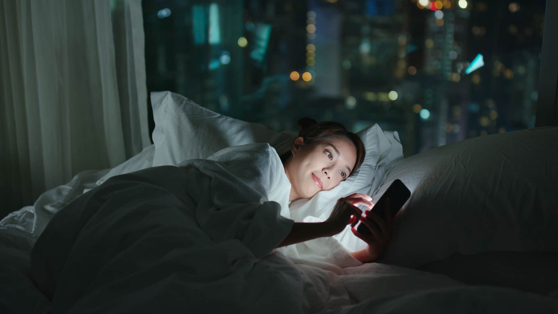 woman checking her phone because she's expected to be available at all hours