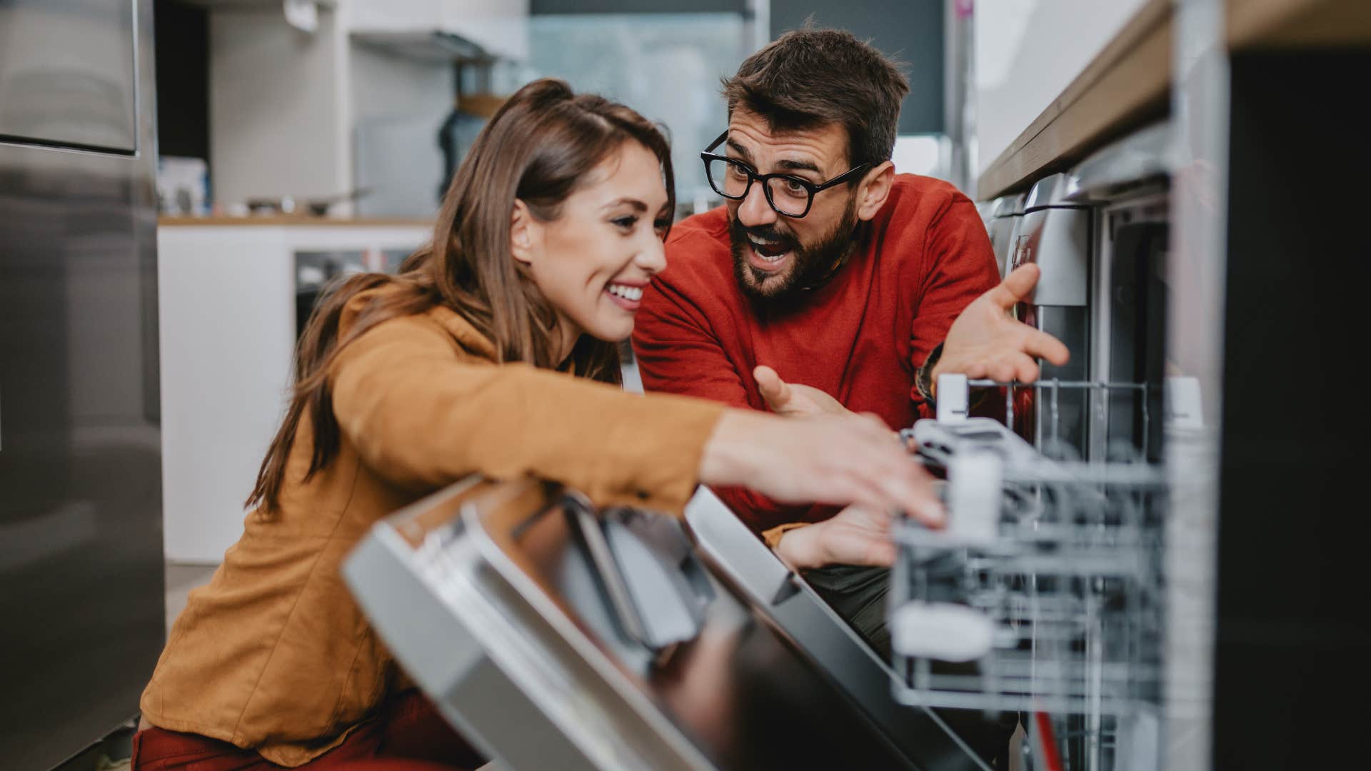 couple smiling and opening the dishwasher before it's done