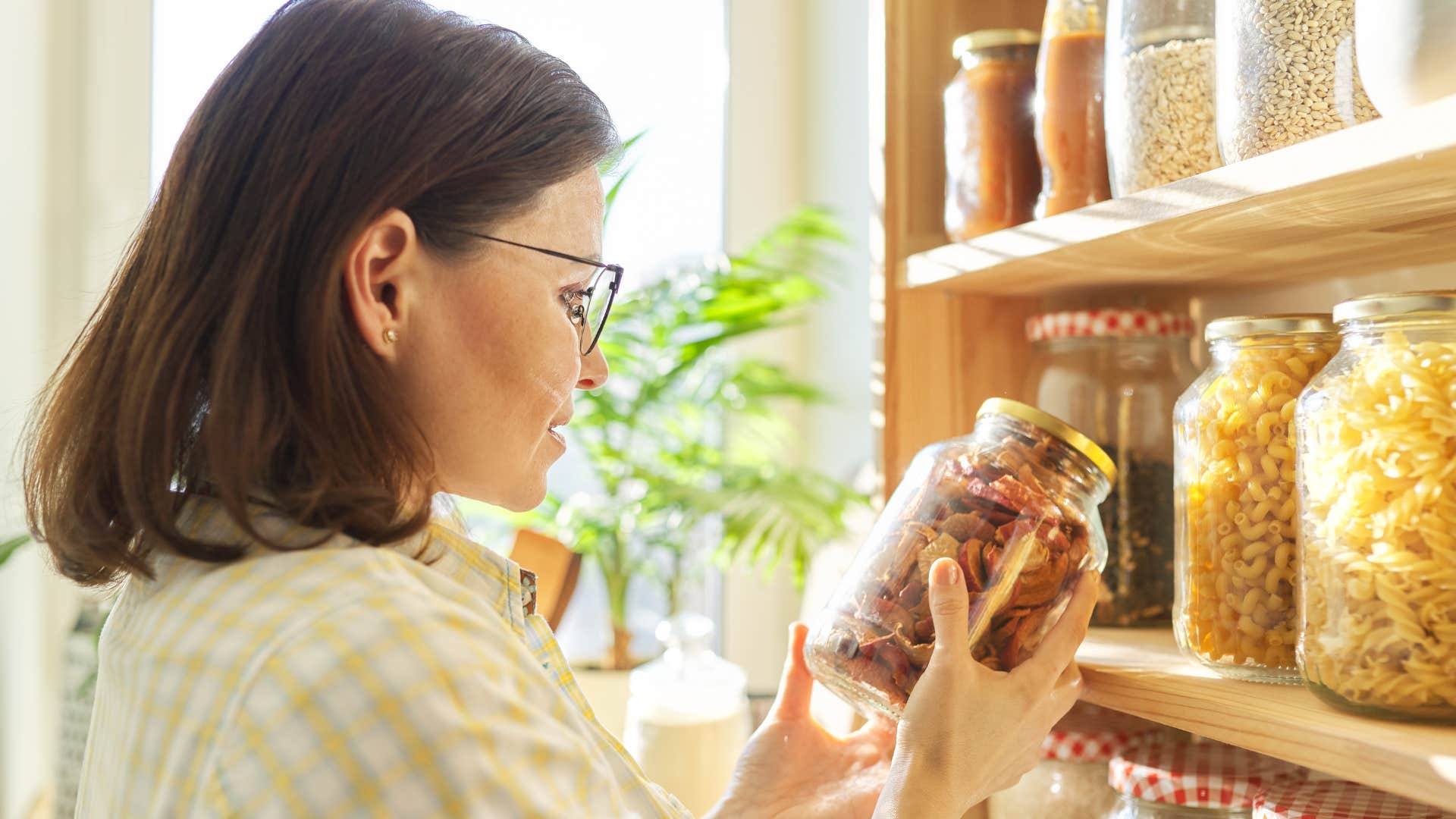 woman reusing old jars in her pantry