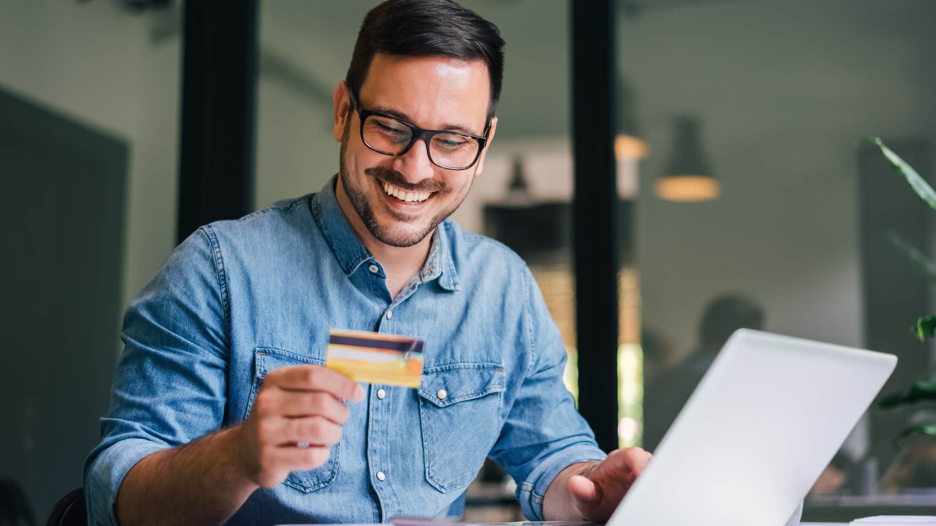 man waiting before making big purchase holding a credit card