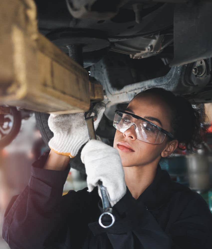 Mechanic works on car.
