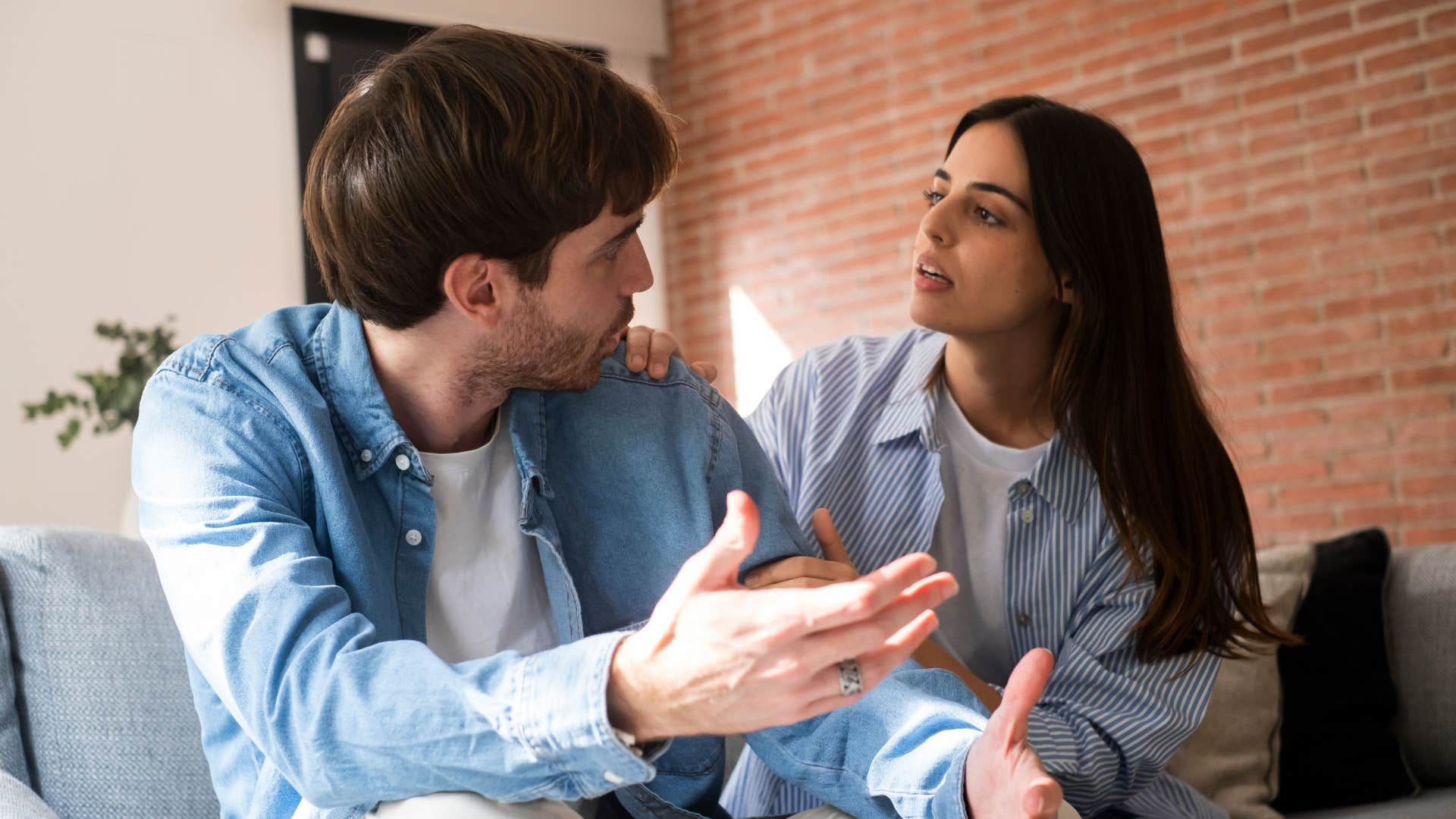 woman in stripped shirt frustrated by the lack of emotional intelligence as man in blue jacket argues with her