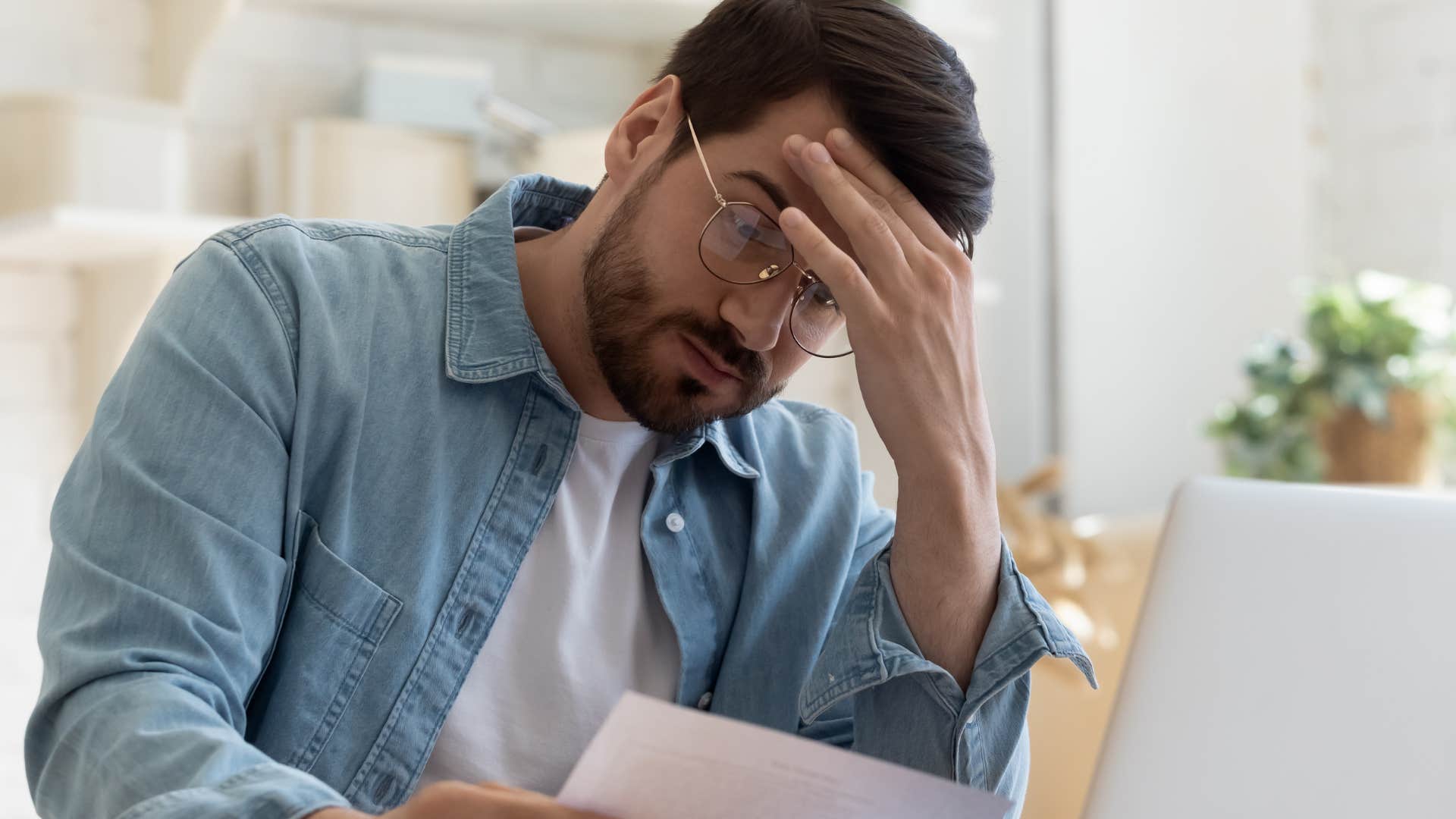 Upset man looking at a paper with all the memberships they don't use on it.