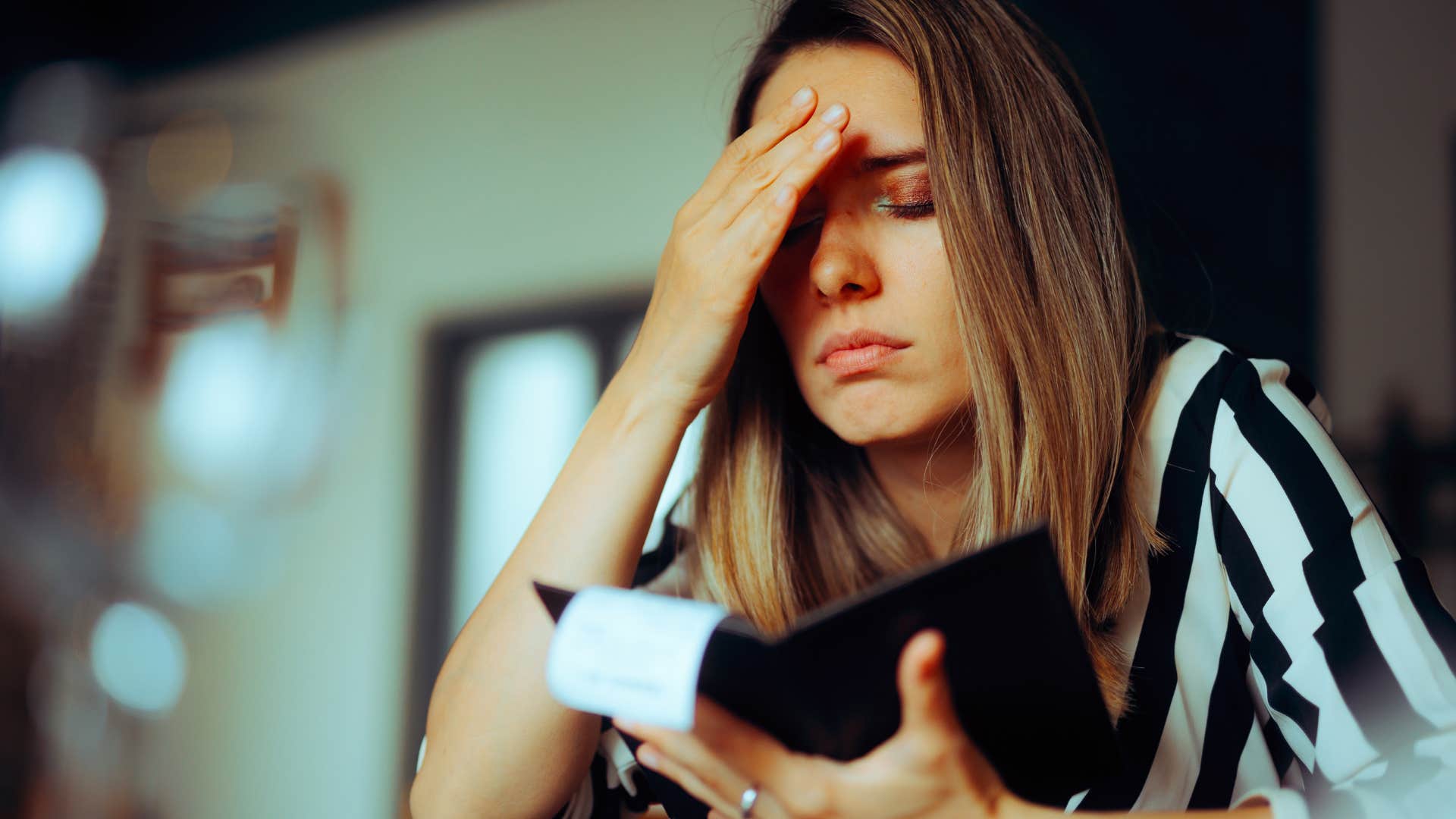 Woman who never saves money looking at the bill.