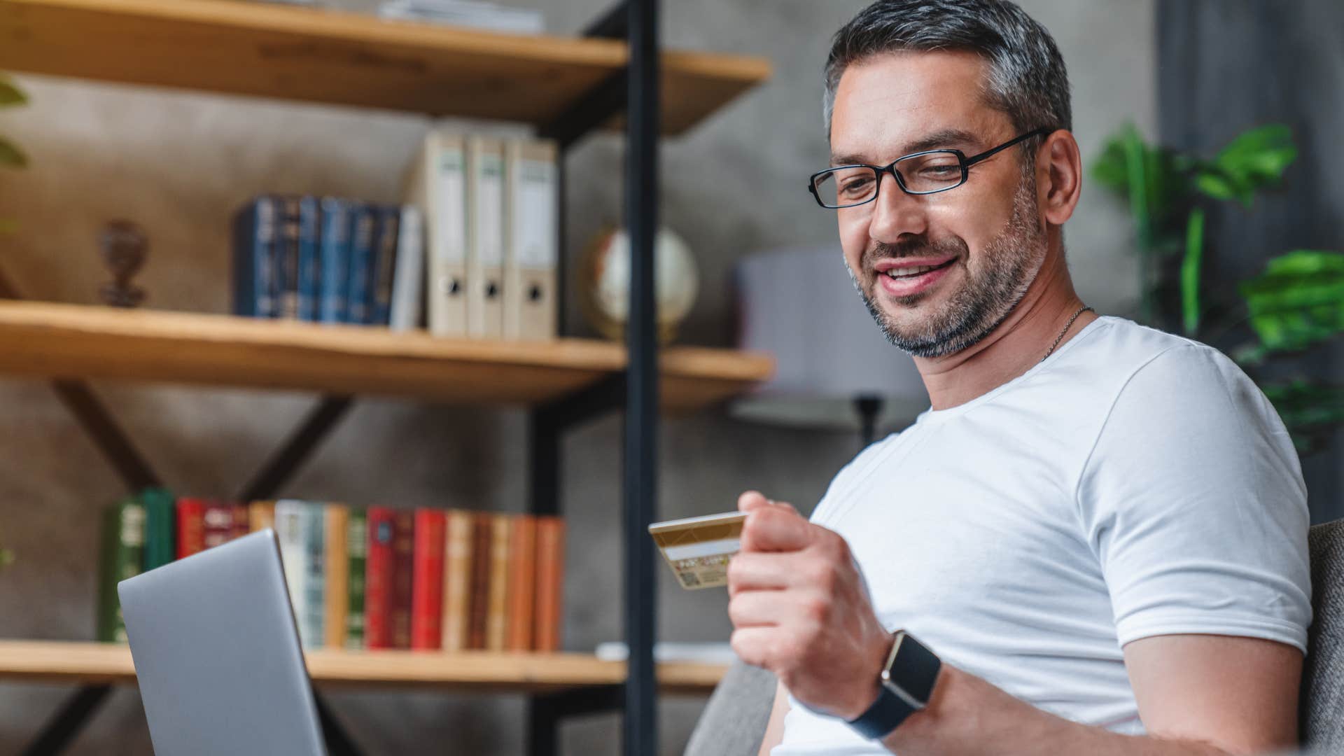 Man who only pays minimum payments holding his credit card.