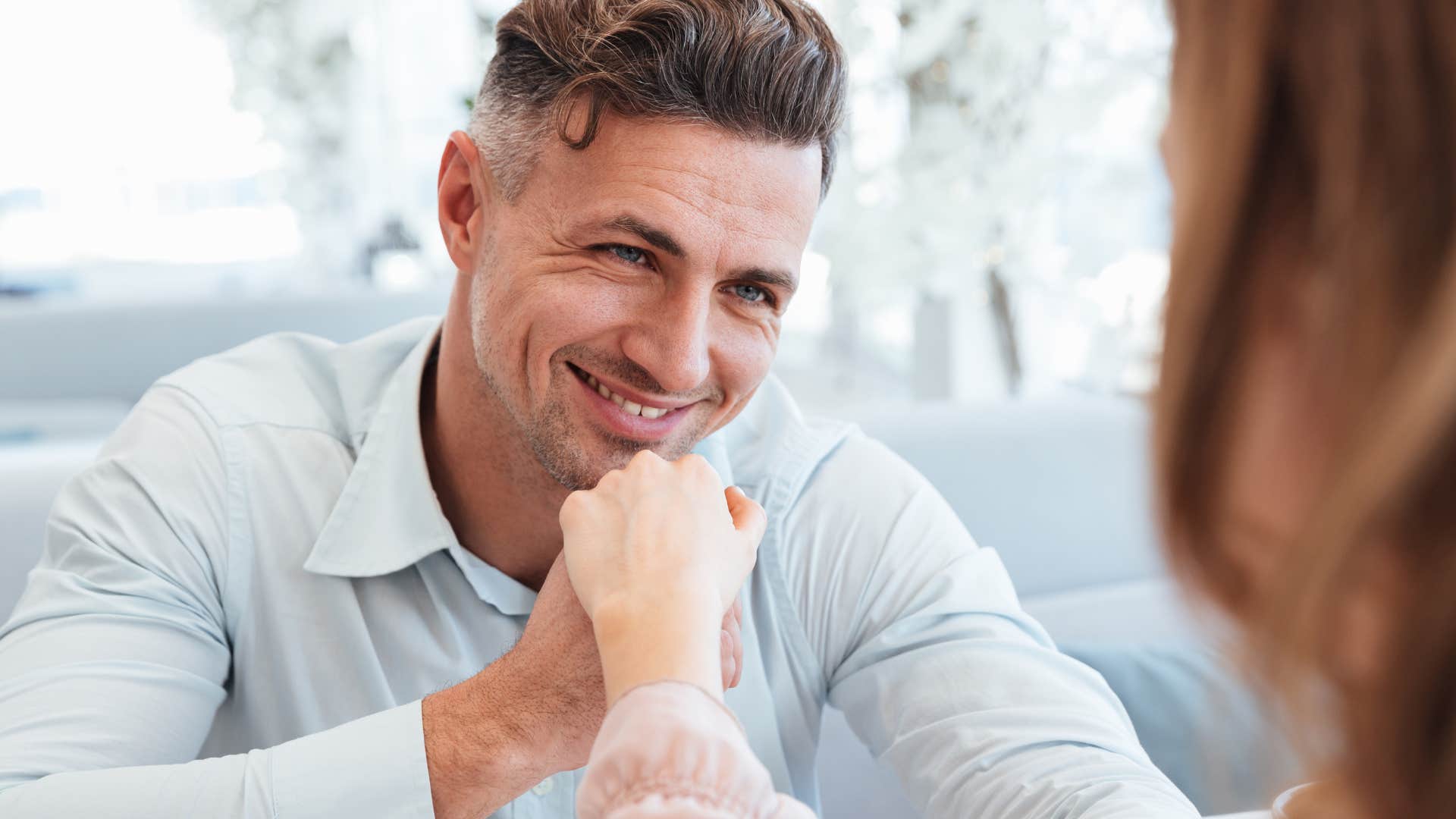 committed man smiling and holding his partner's hand