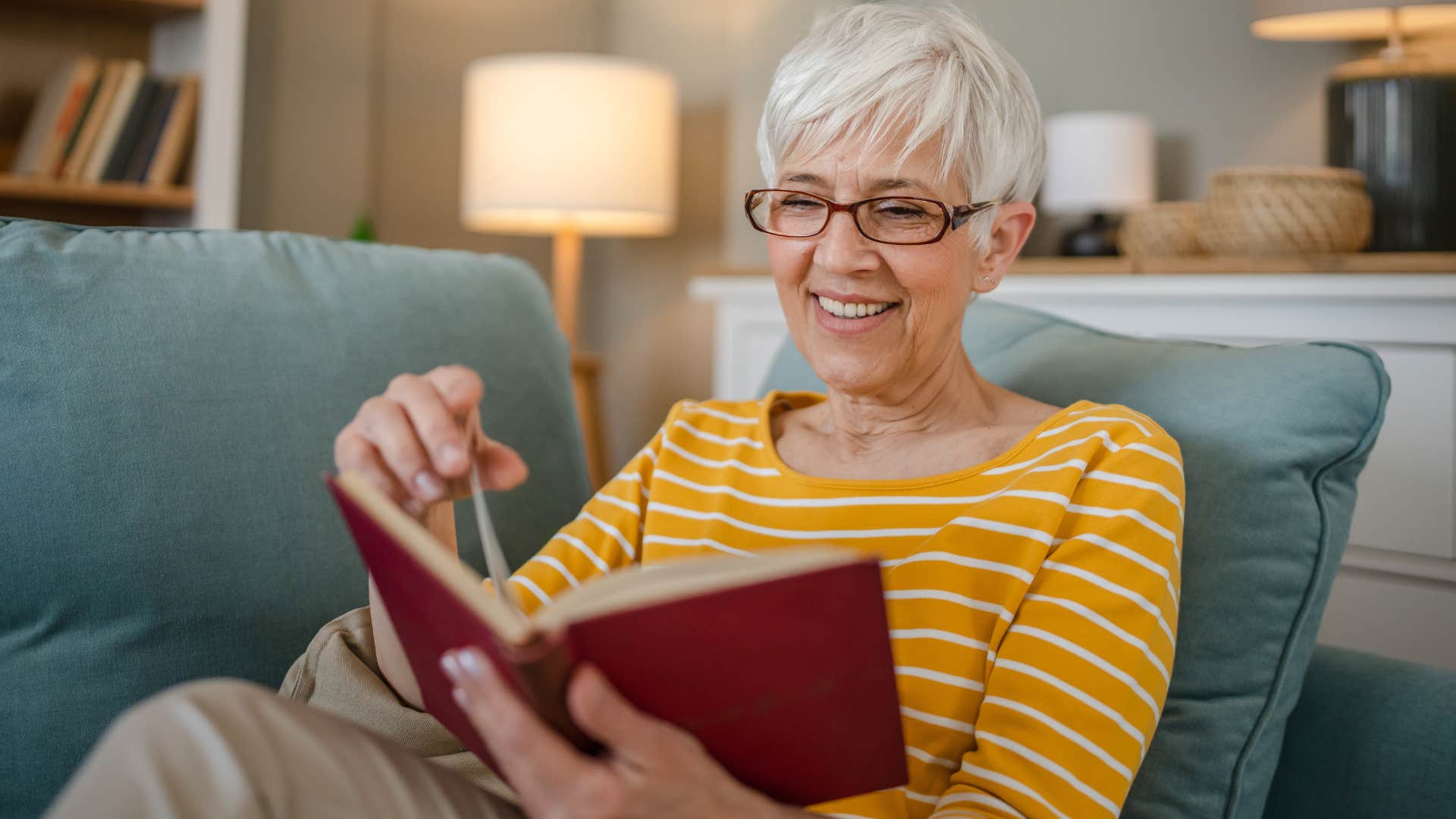 woman who enjoys alone time reading on her couch