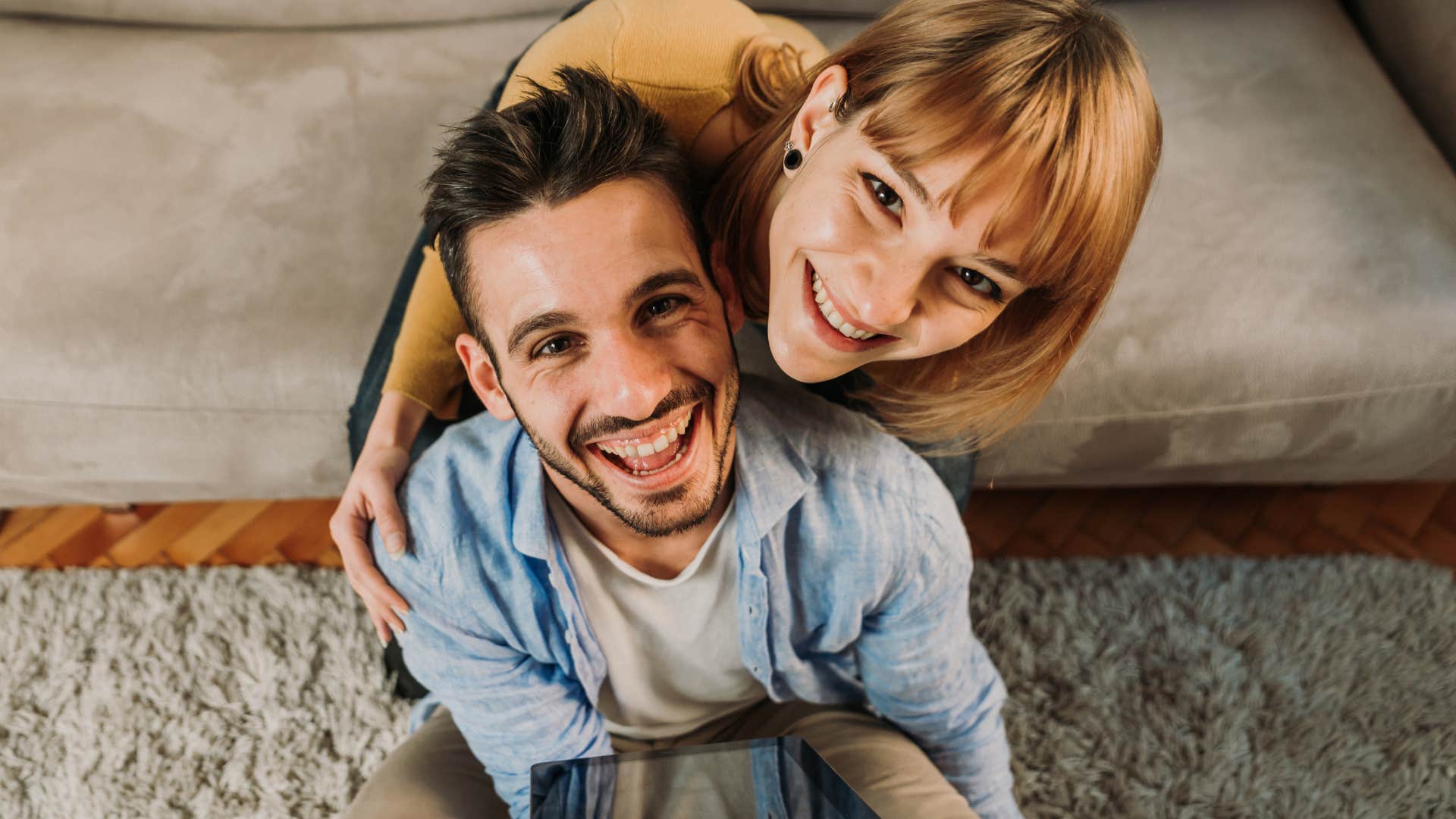self-aware man smiling with his partner in the living room
