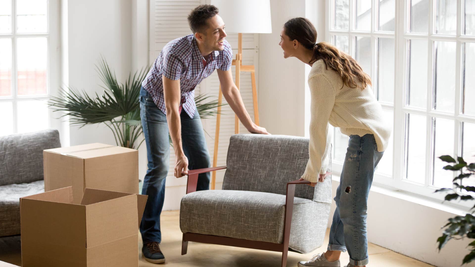 couple rearranging furniture for feng shui
