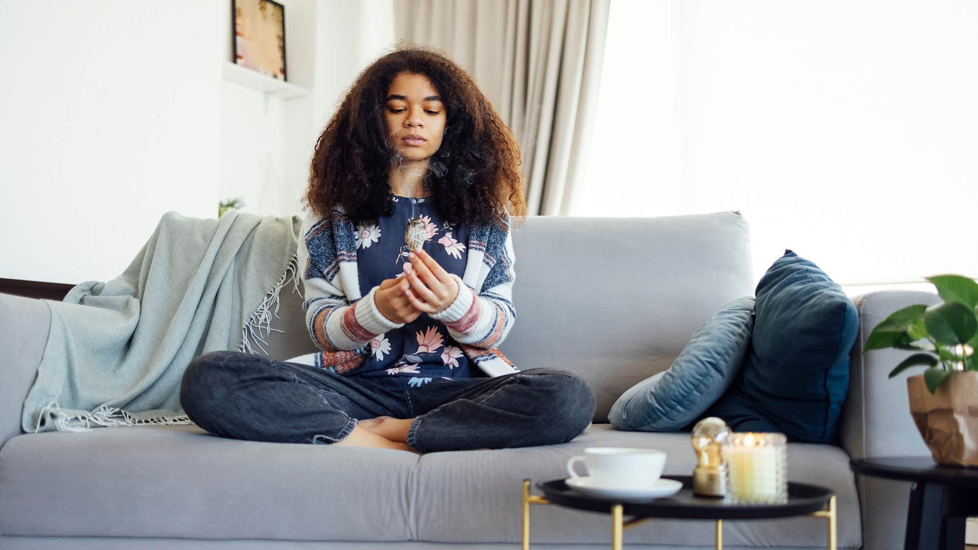 woman smudging her home meditating