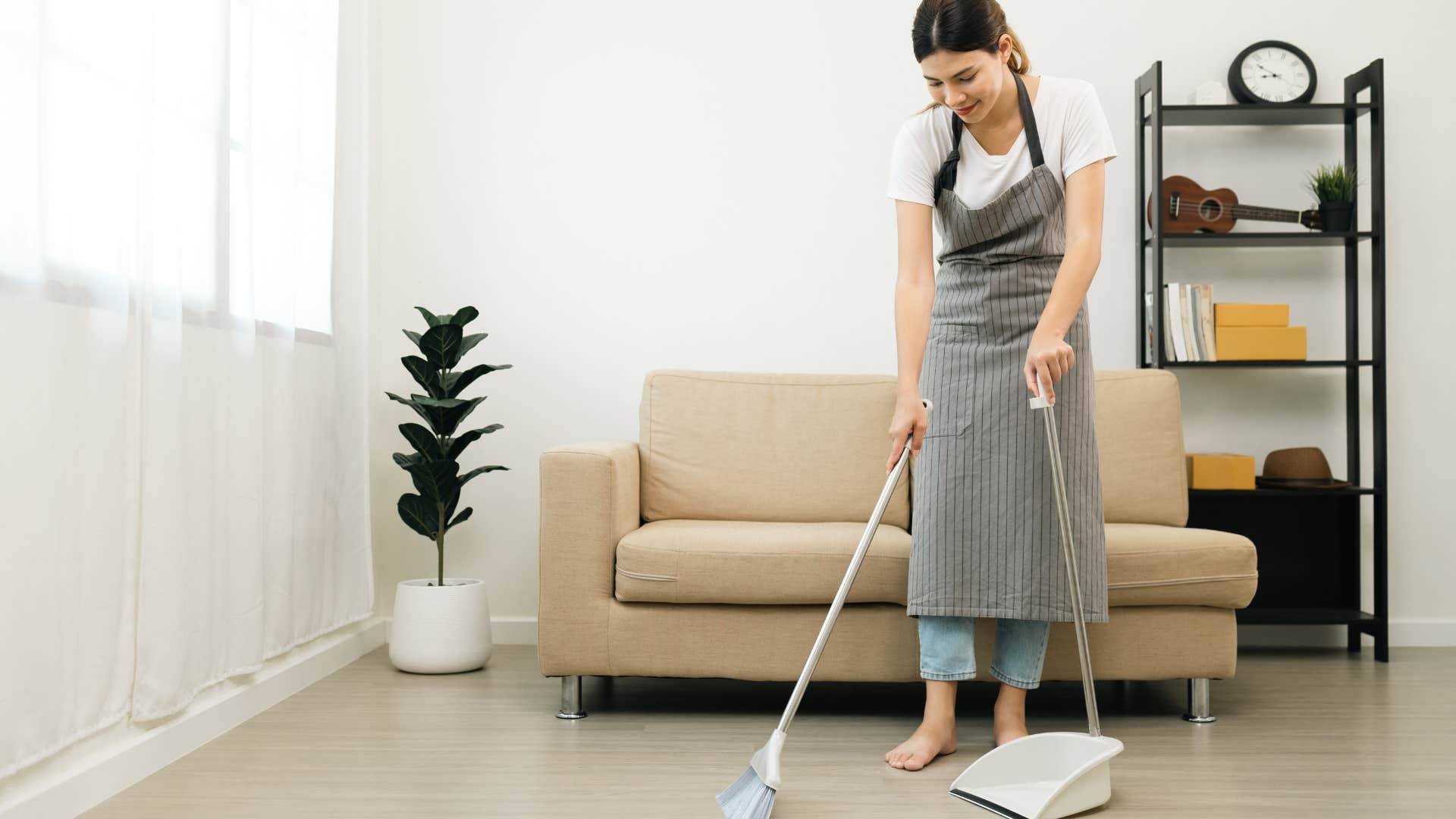 woman sweeping her home to remove negative energy