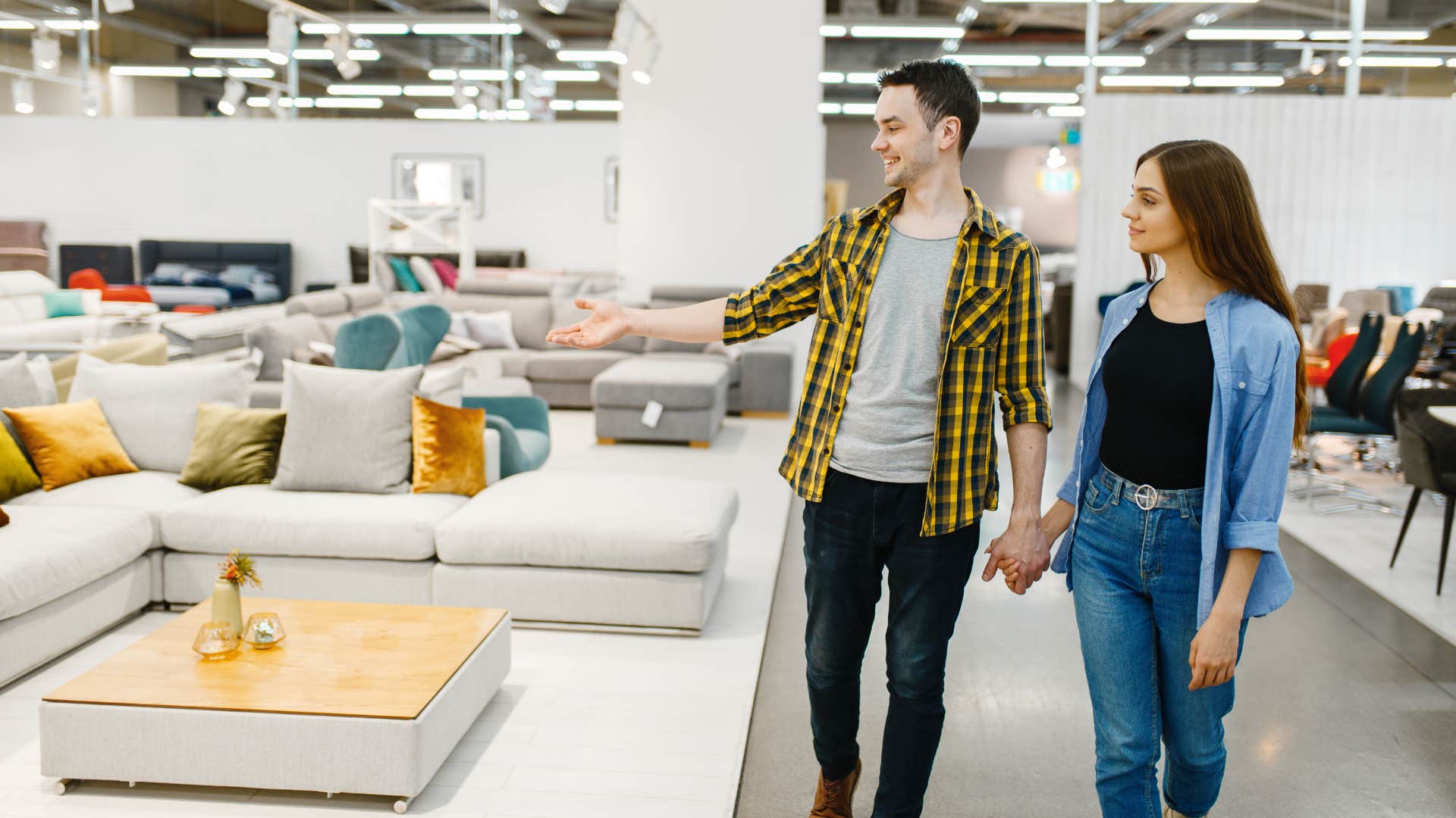 couple buying new instead of shopping second hand as they look through furniture