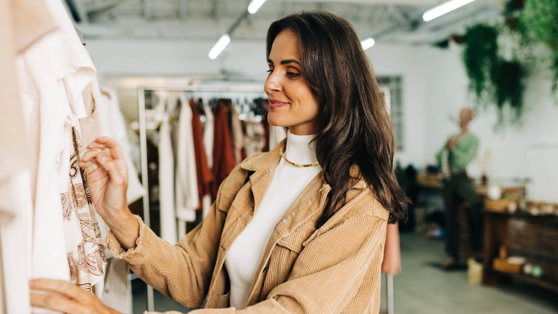 woman looking through clothes as she maxes out her credit card for designer brands