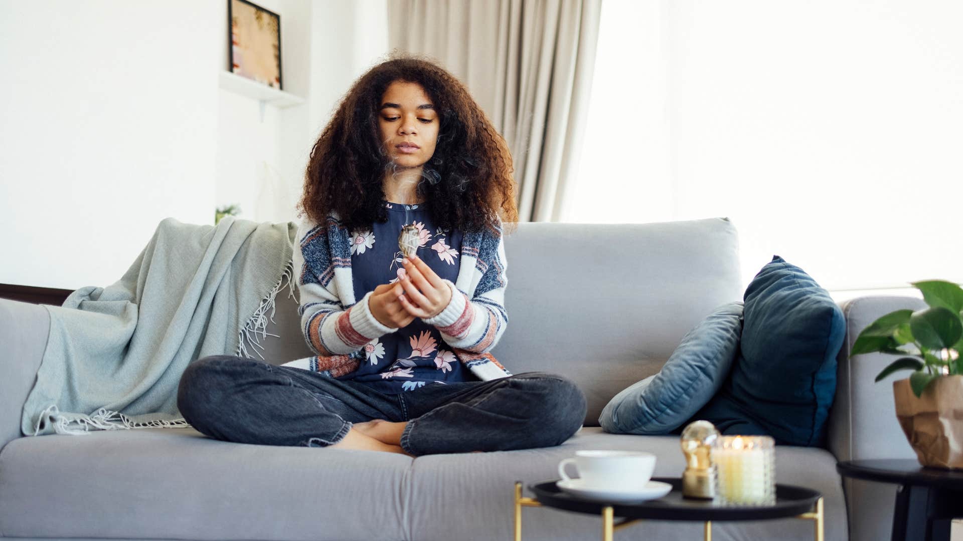 young woman meditating on the couch