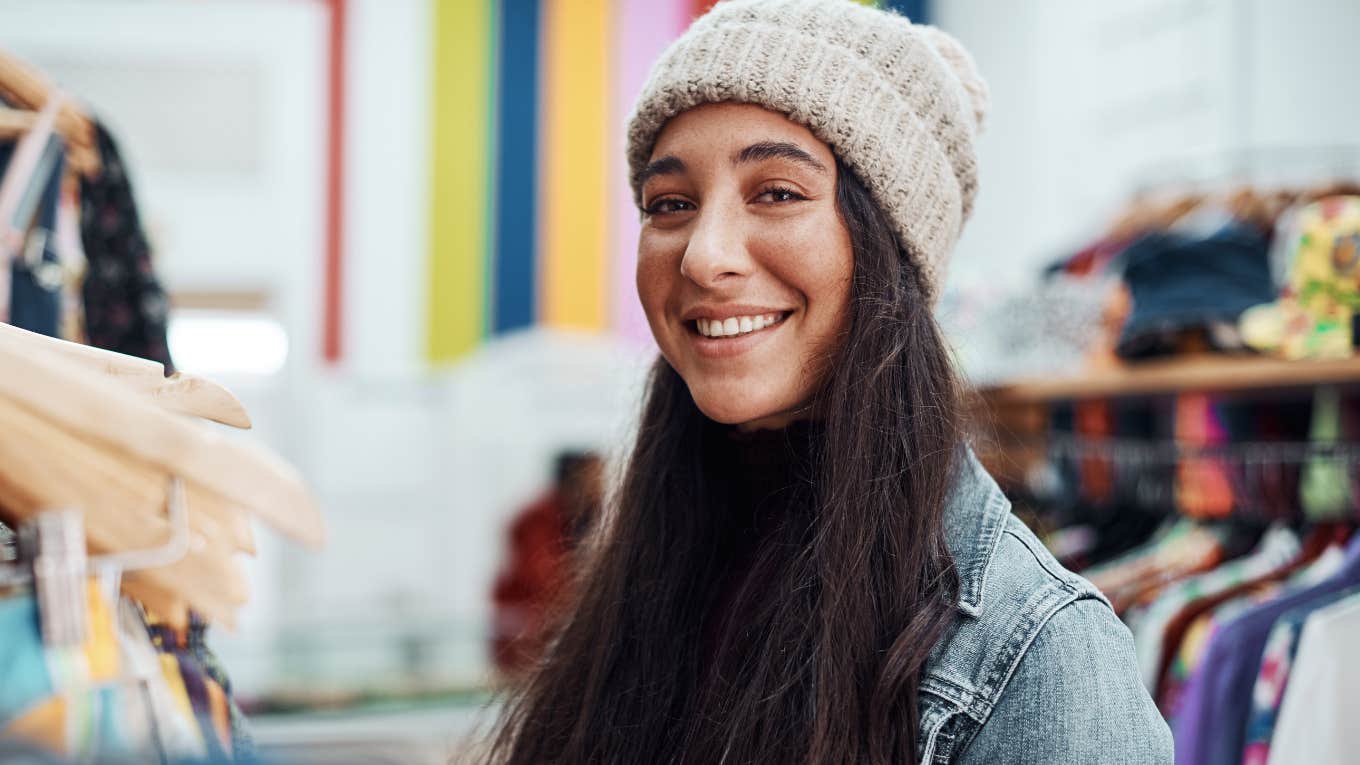Everyday Items People Hoard For No Good Reason woman smiling hoarding clothes in her closet