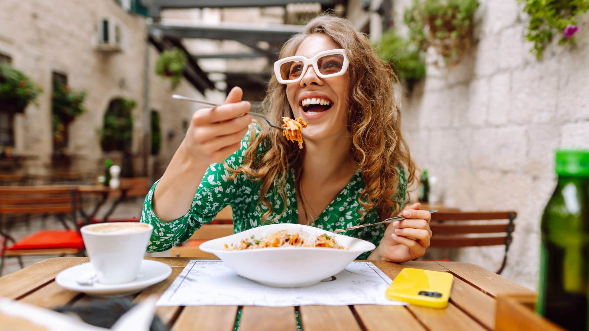 Woman smiling and eating expensive meals at a restaurant.