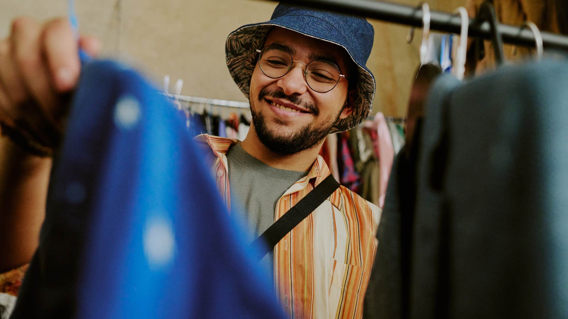 Man looking through sustainable options at a thrift store.