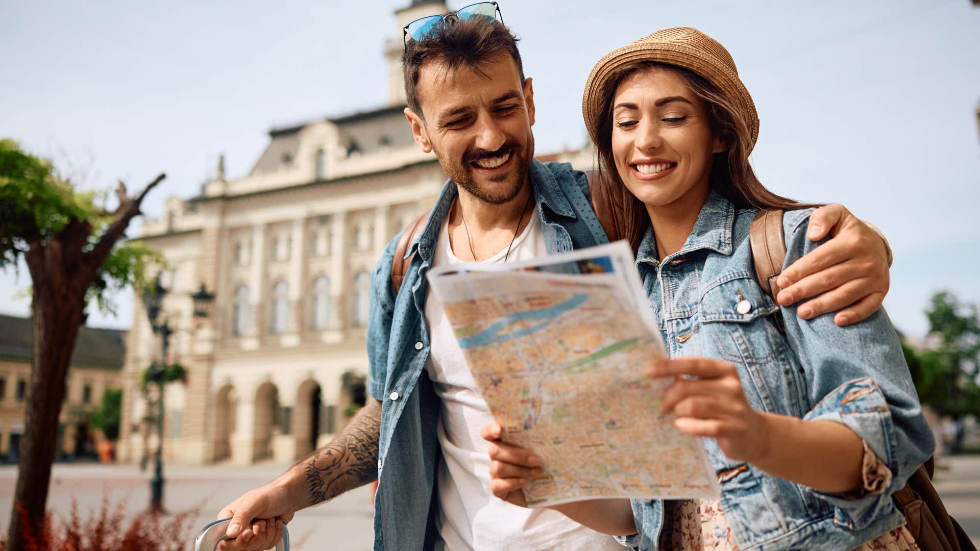 Couple smiling with a map on a vacation.