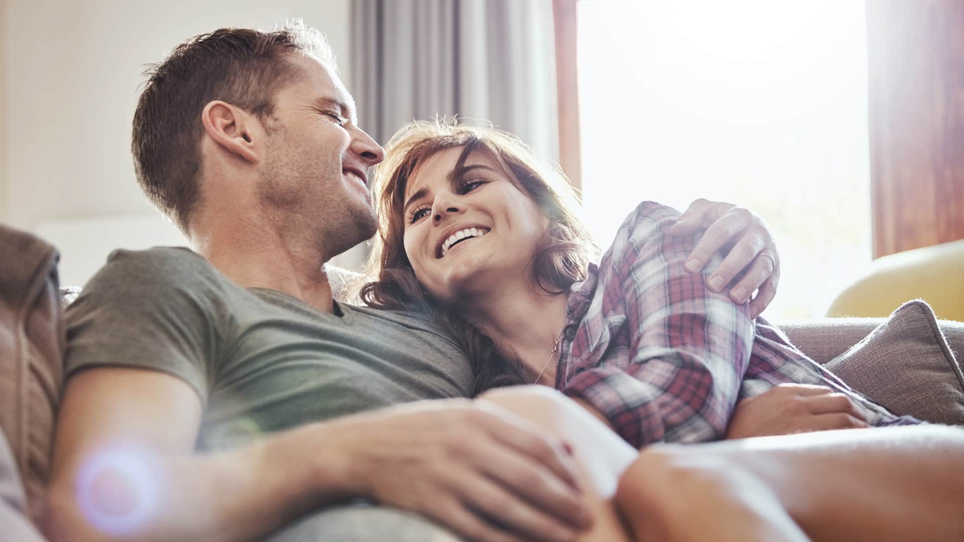 couple who are their genuine selves around each other smiling cuddling