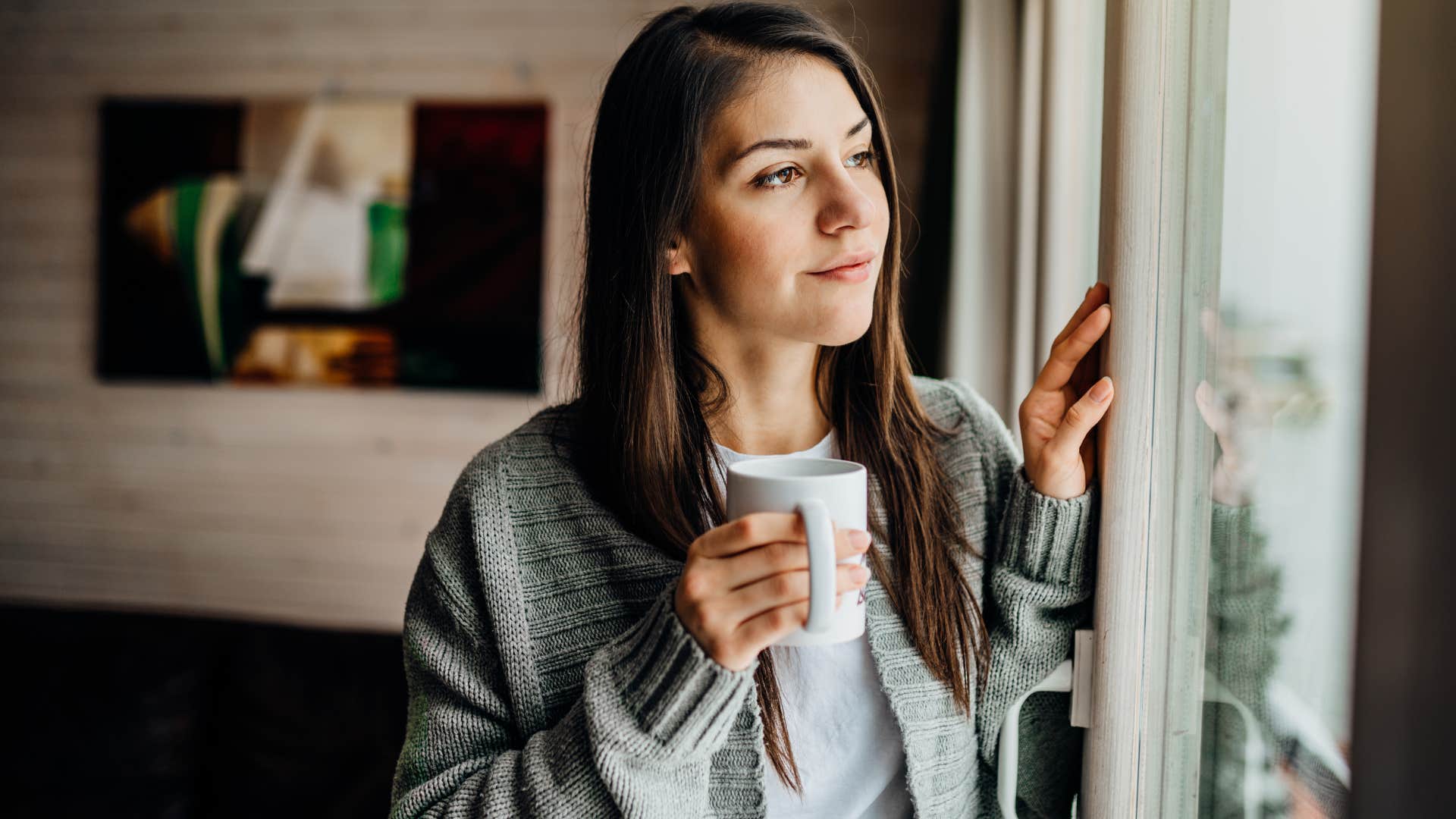 Woman who can prioritize solitude looking out a window.