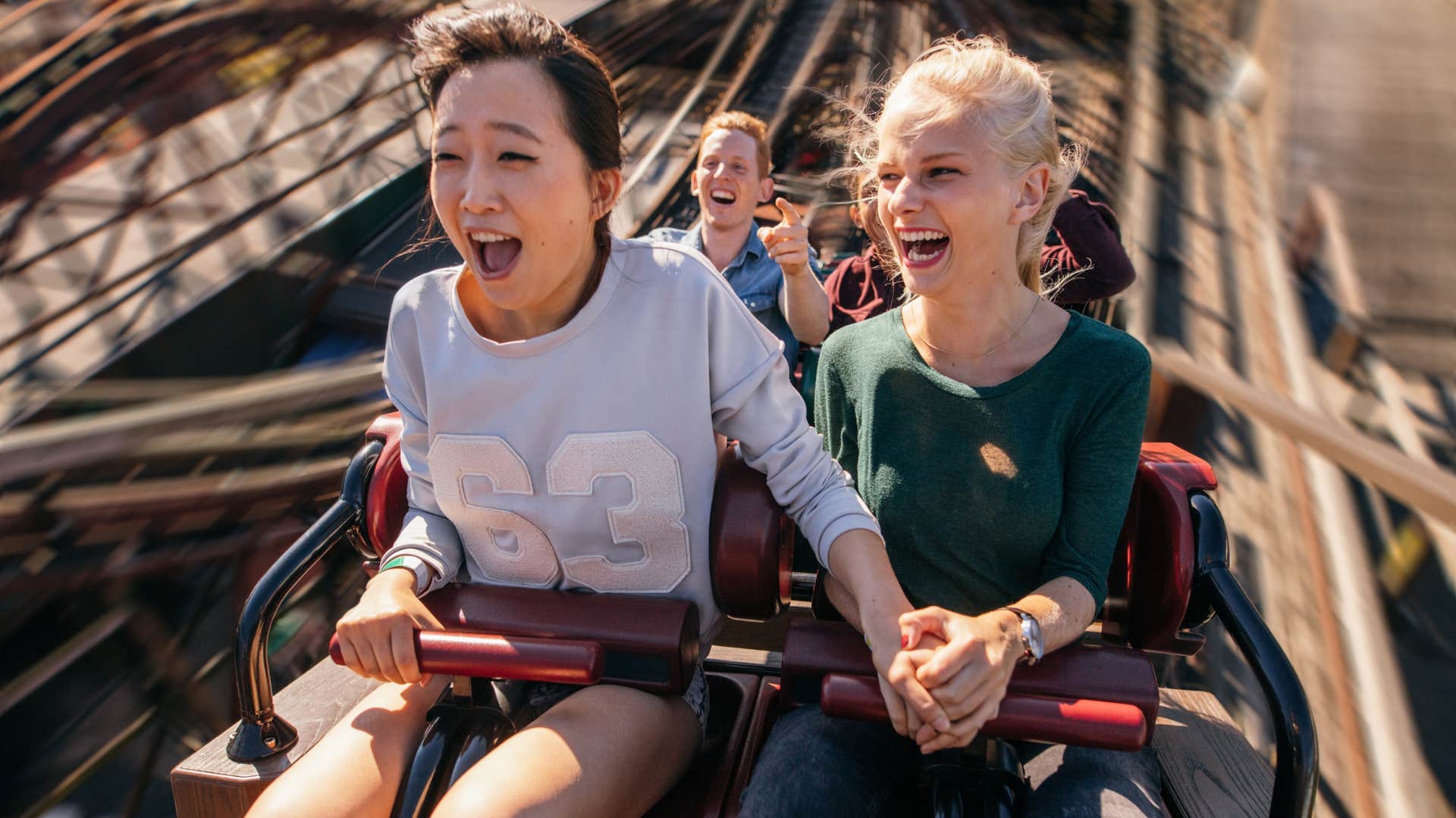 classy woman riding a roller coaster because it scares her