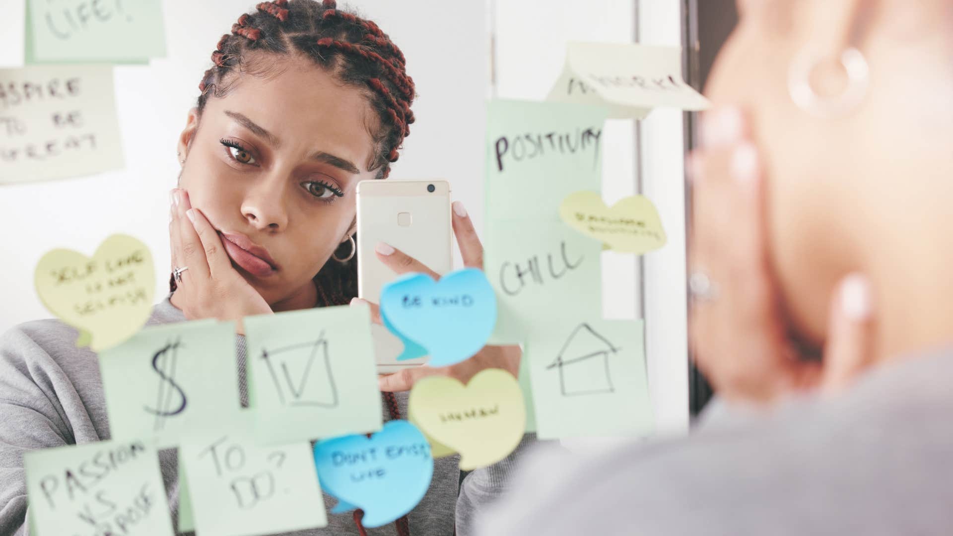 woman looking at positive affirmation sticky notes